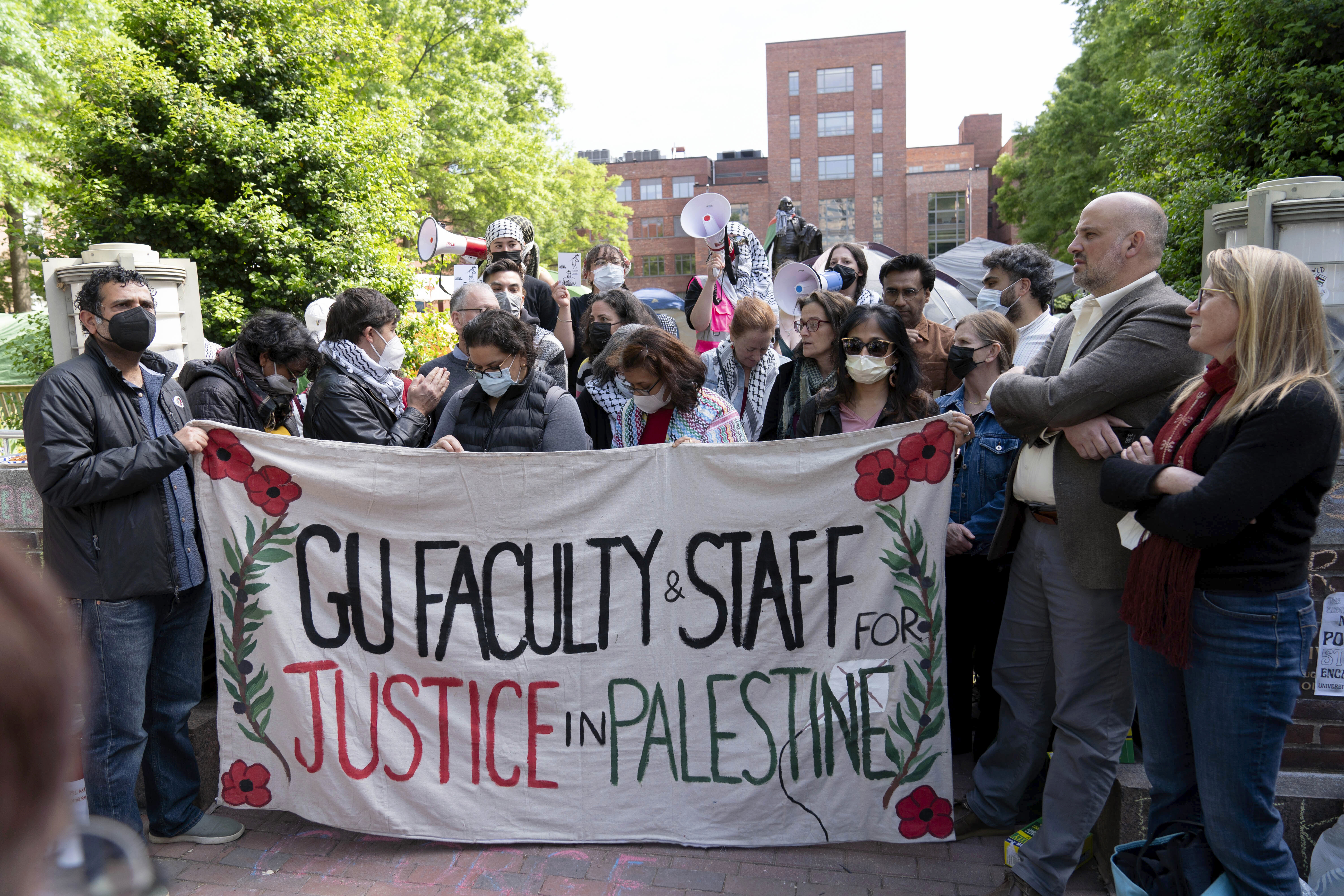 George Washington University professors Rochelle Davis, from right, and Will Youmans lead a group of professors during a pro-Palestinian protest over the Israel-Hamas war on Friday, April 26
