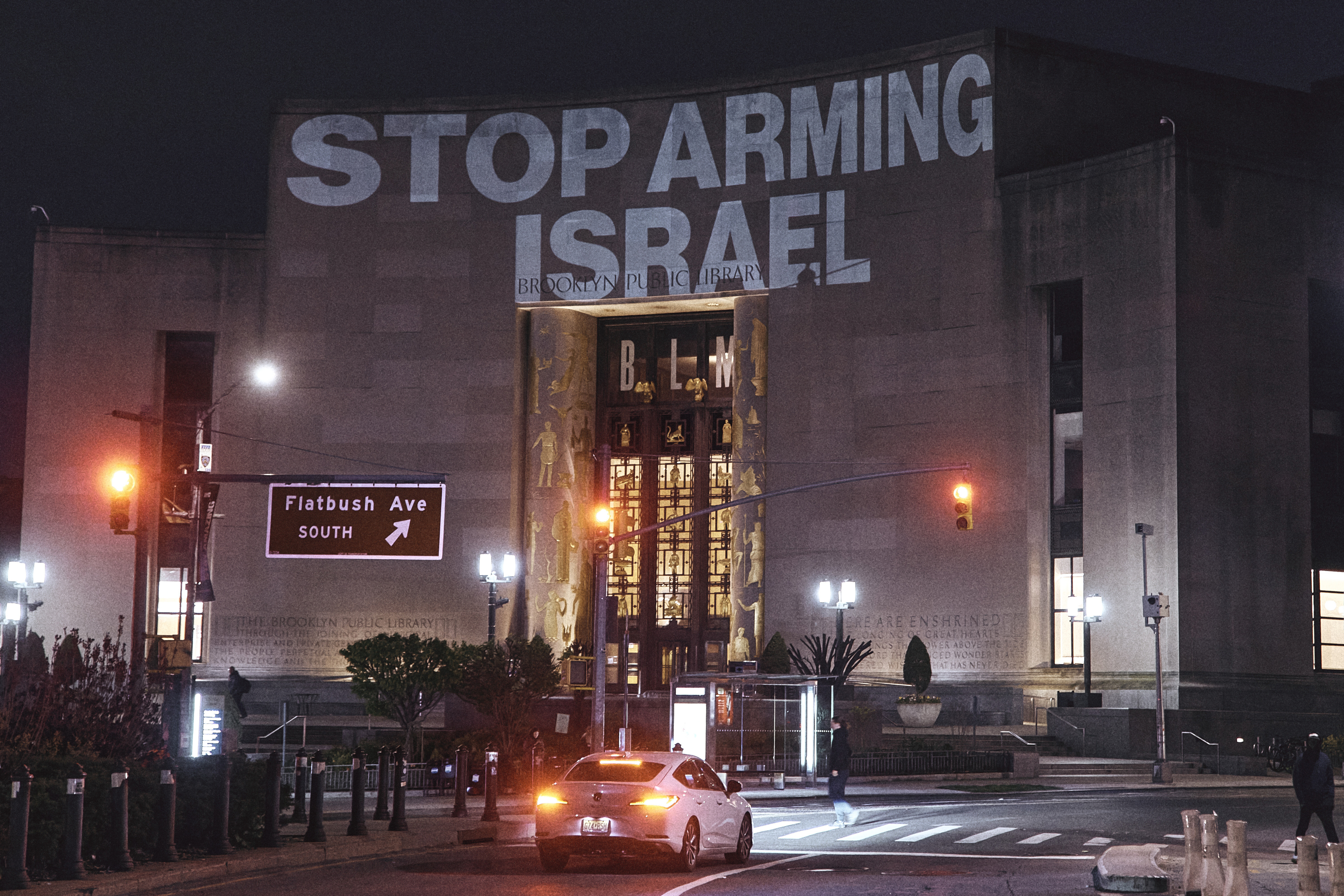 Protesters project a banner reading 'Stop arming Israel'