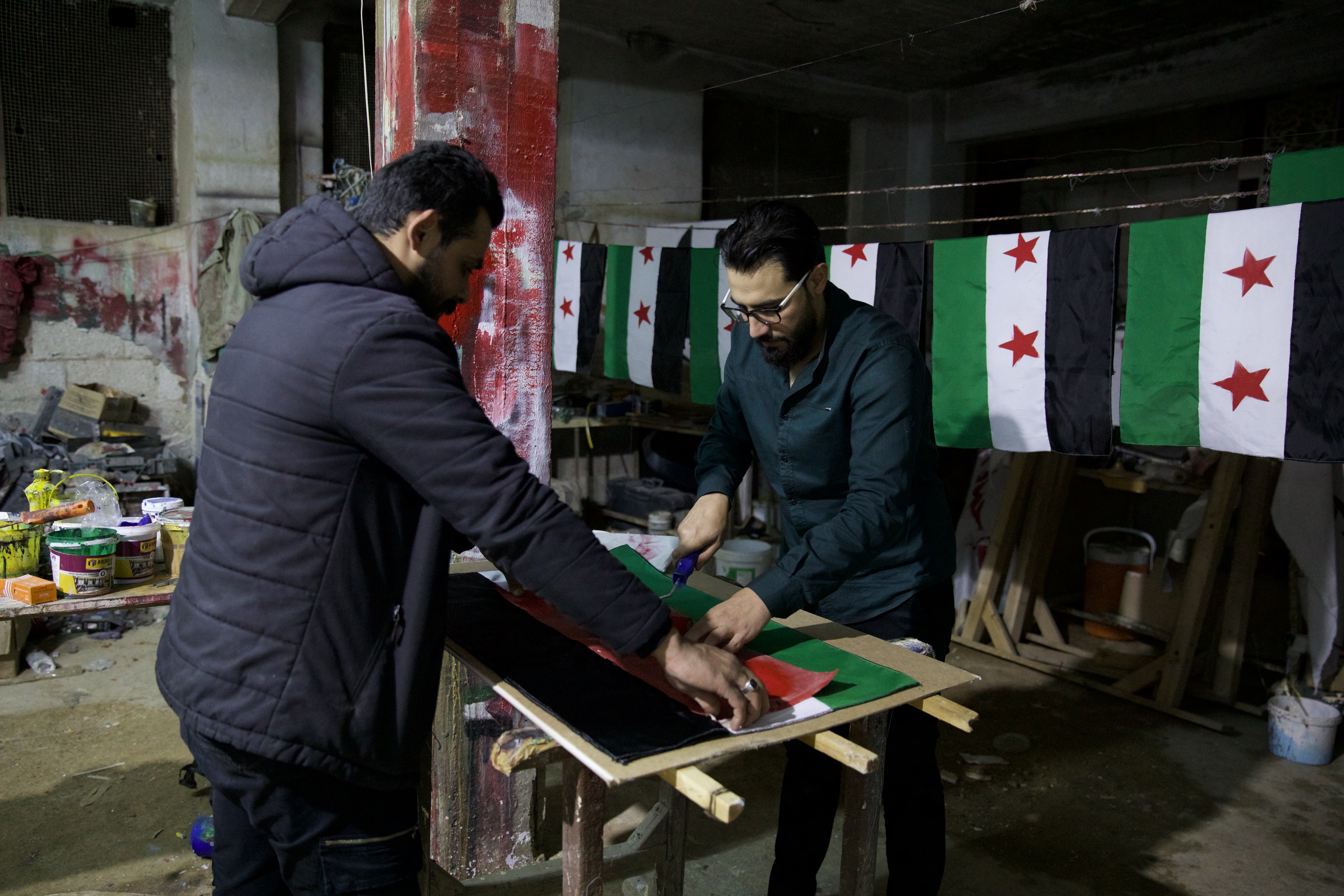 Two men prepare a Syrian opposition flag