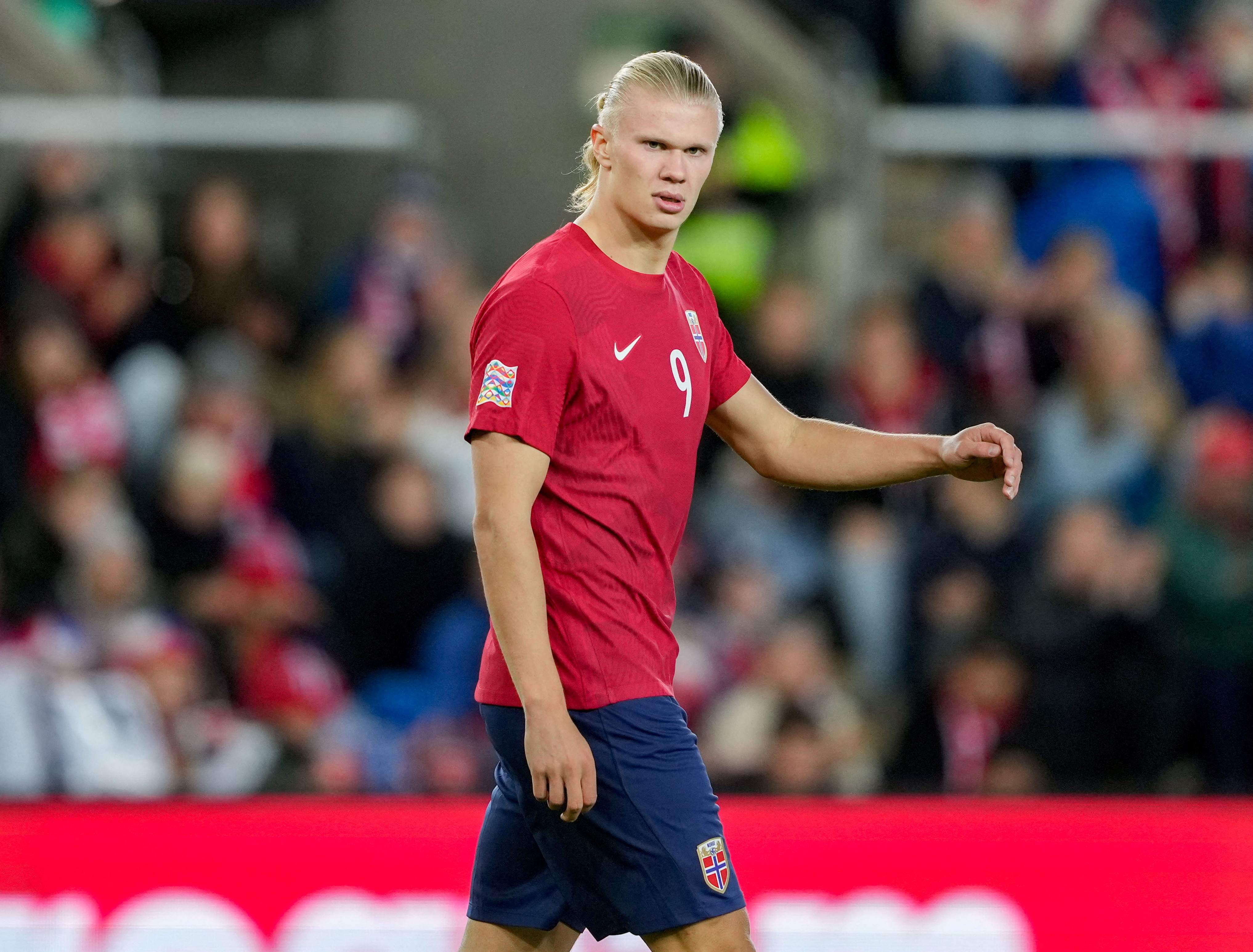Football player looking at crowd while he walks.