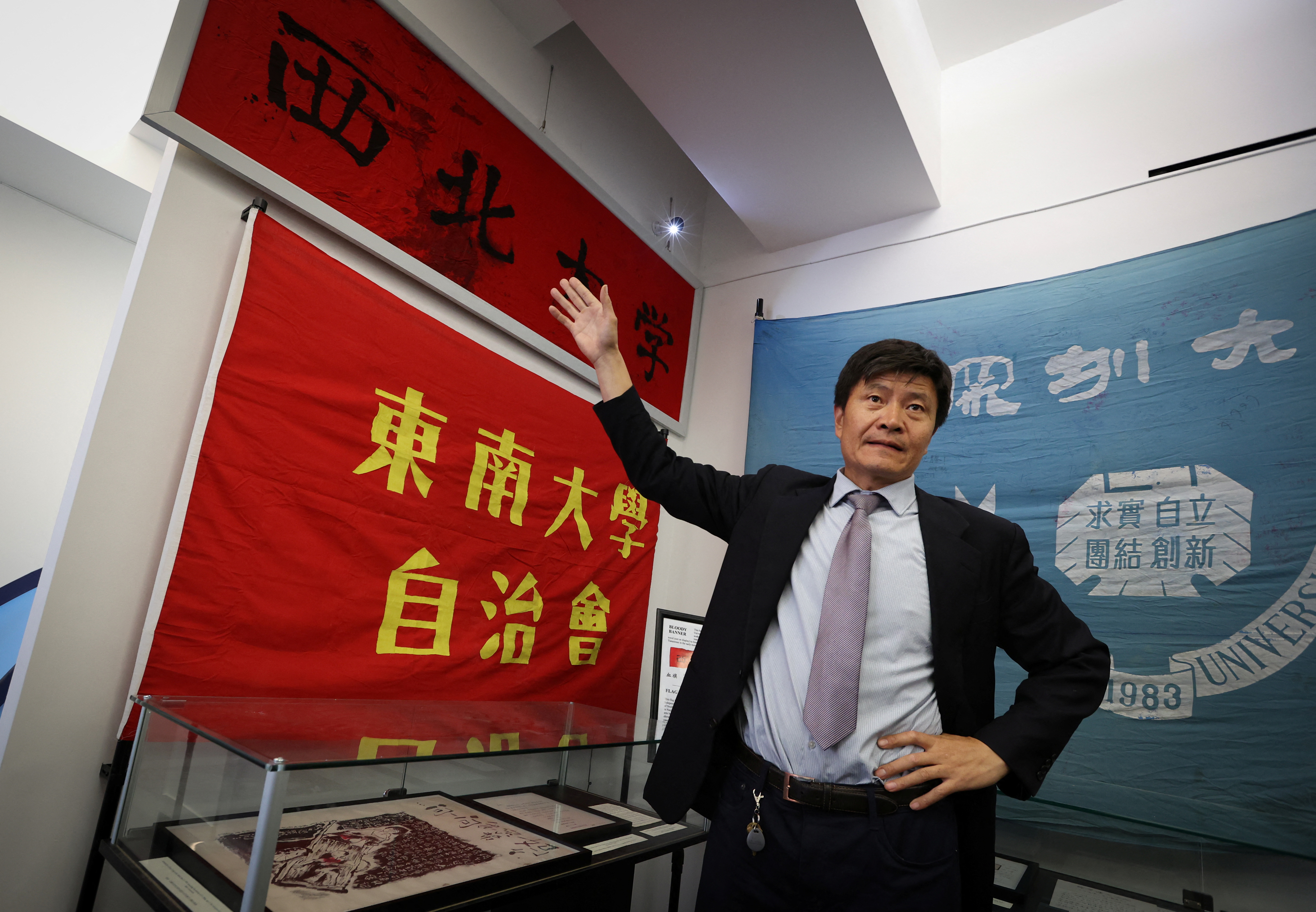 Zhou Fengsuo, curator of the Tiananmen museum in New York.. He is pointing at a banner that was used to bind a student's injuries after they were hit by live fire from the military. The blood stains are clearly visible.