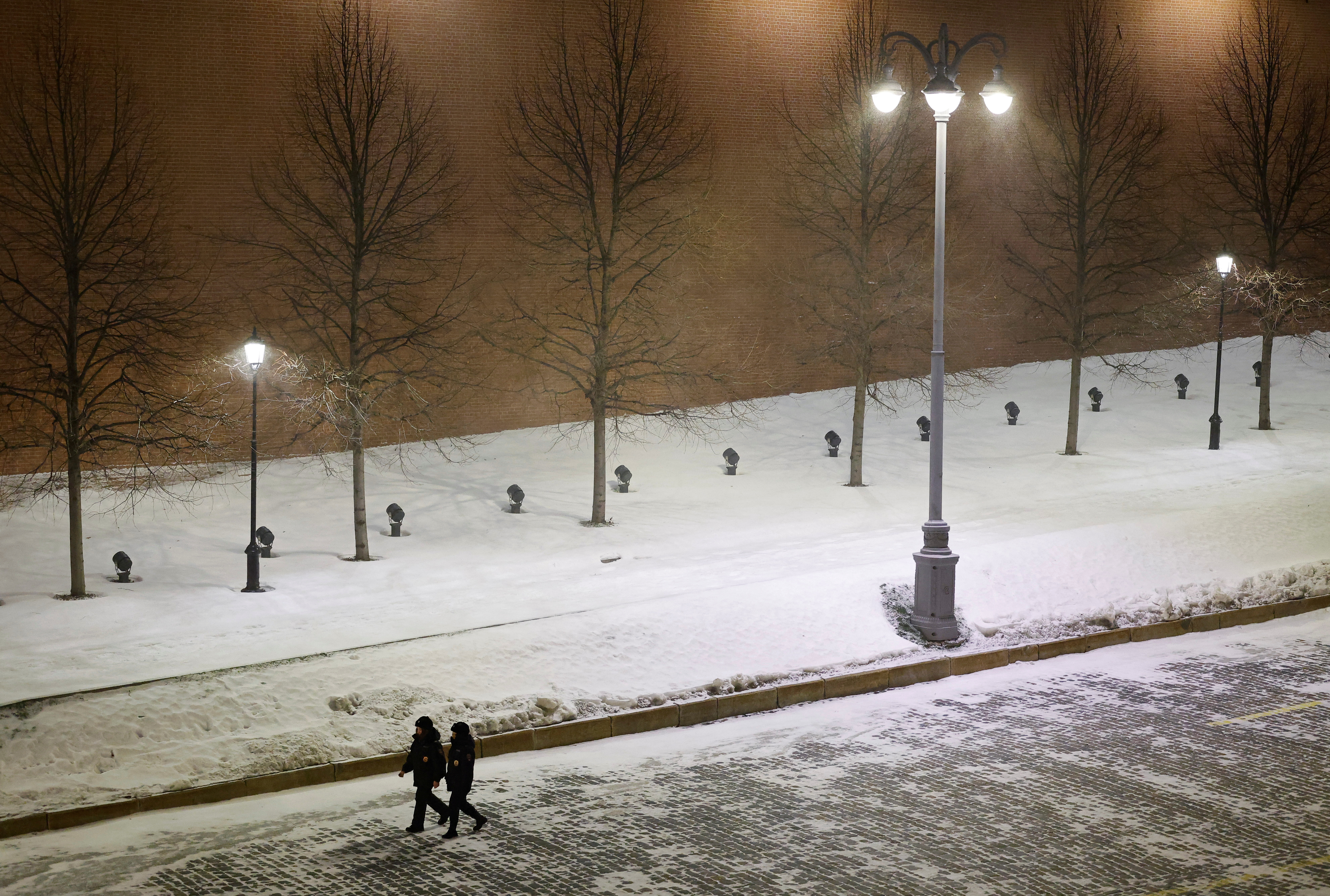 Law enforcement officers walk along the Kremlin