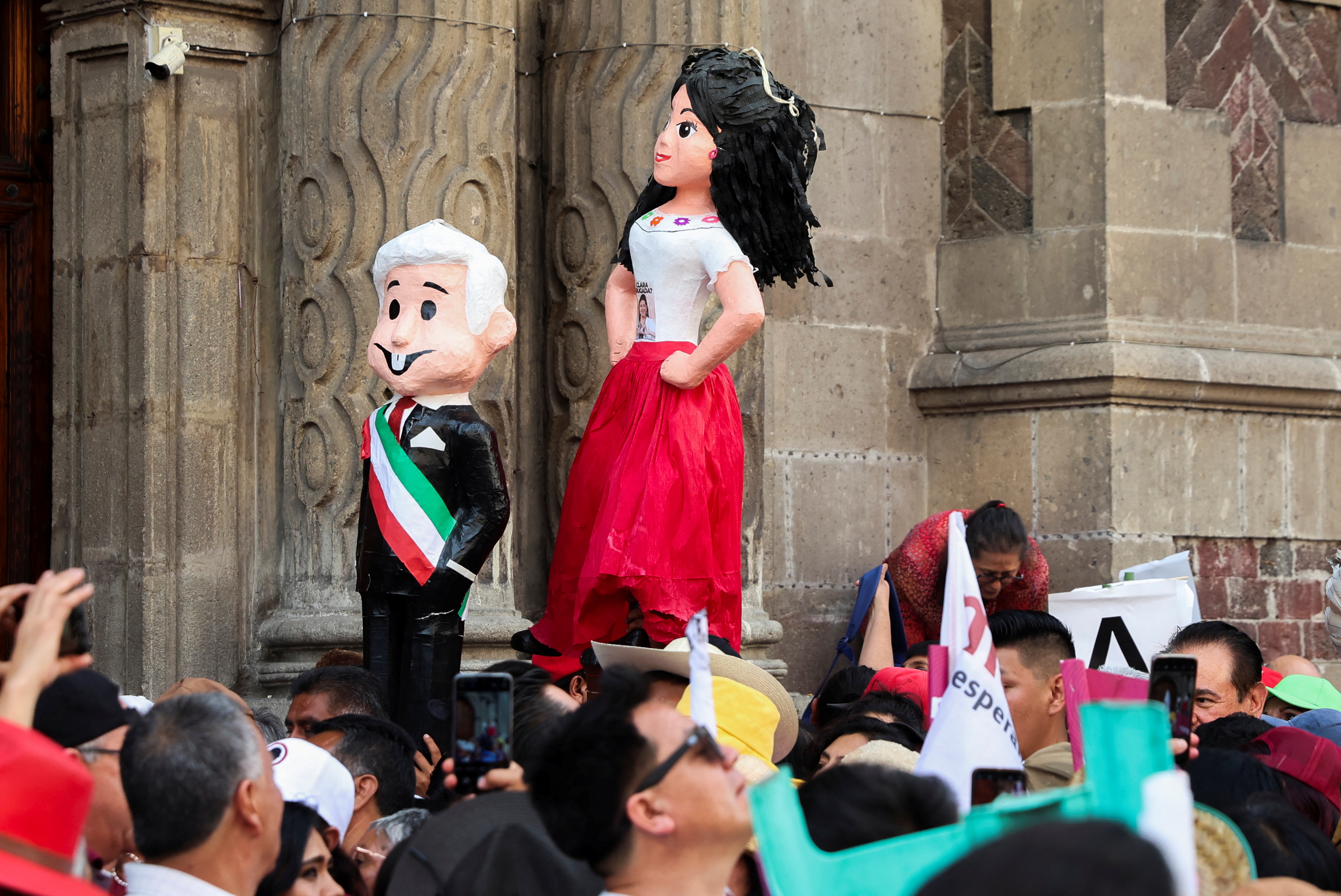 Supporters raise effigies of Andres Manuel Lopez Obrador and Claudia Sheinbaum at a rally.