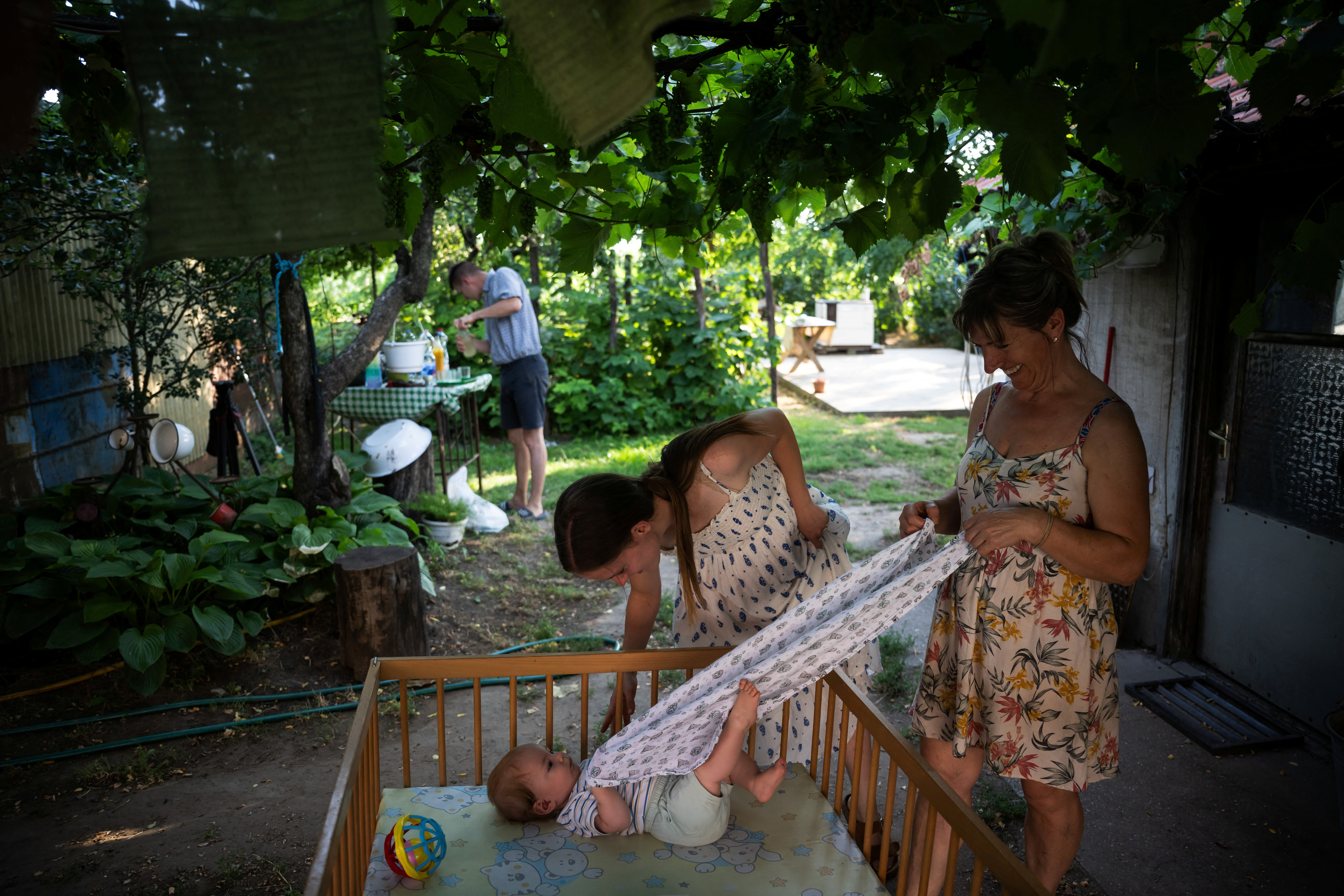 Petra Pogany-Bago, 24, and her mother Marsa Irma play with Petra's son, Mihaly Pogany, at their farm near Kecskemet, Hungary, July 16