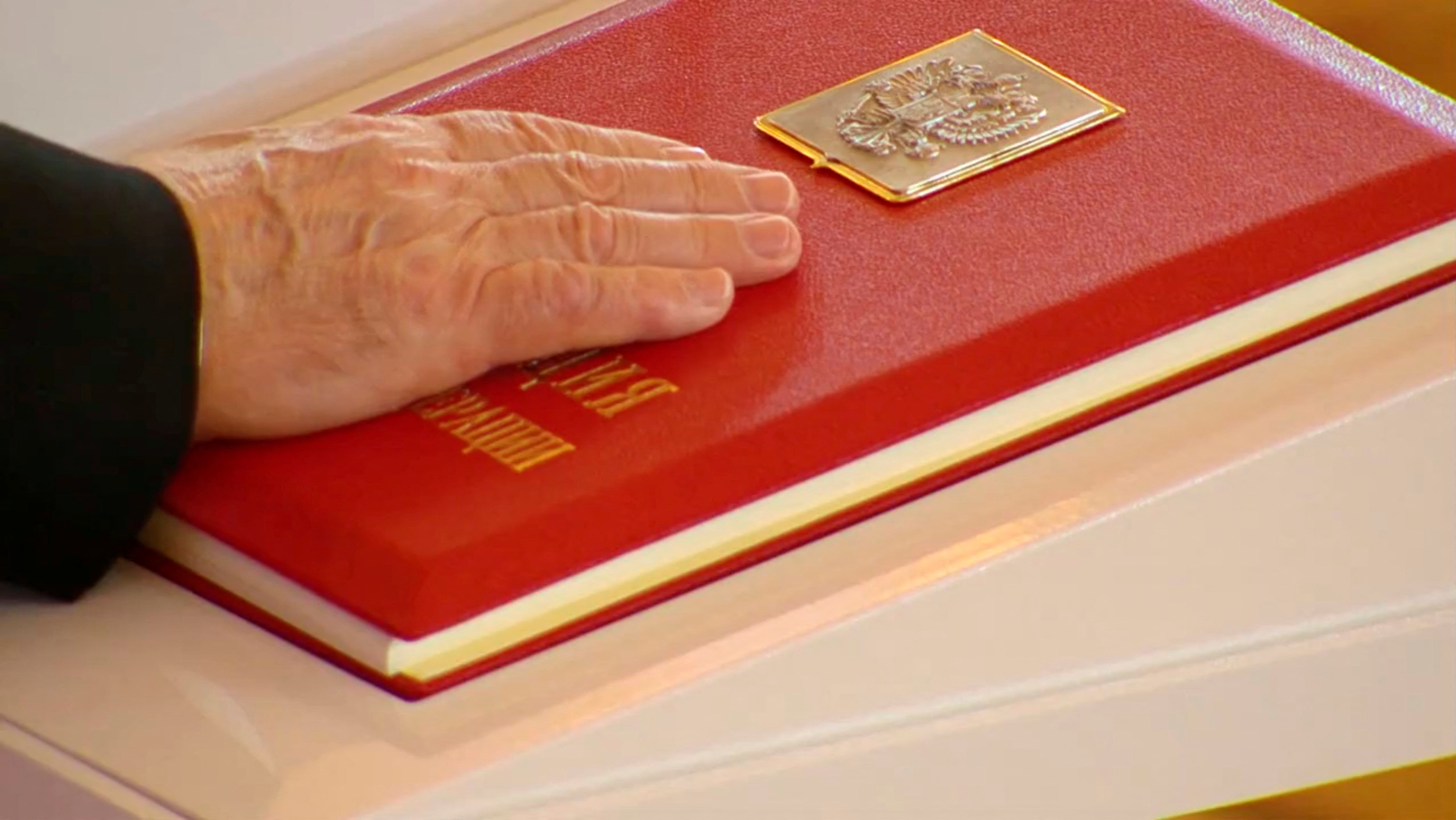 Russian President Vladimir Putin places his hand on the Constitution