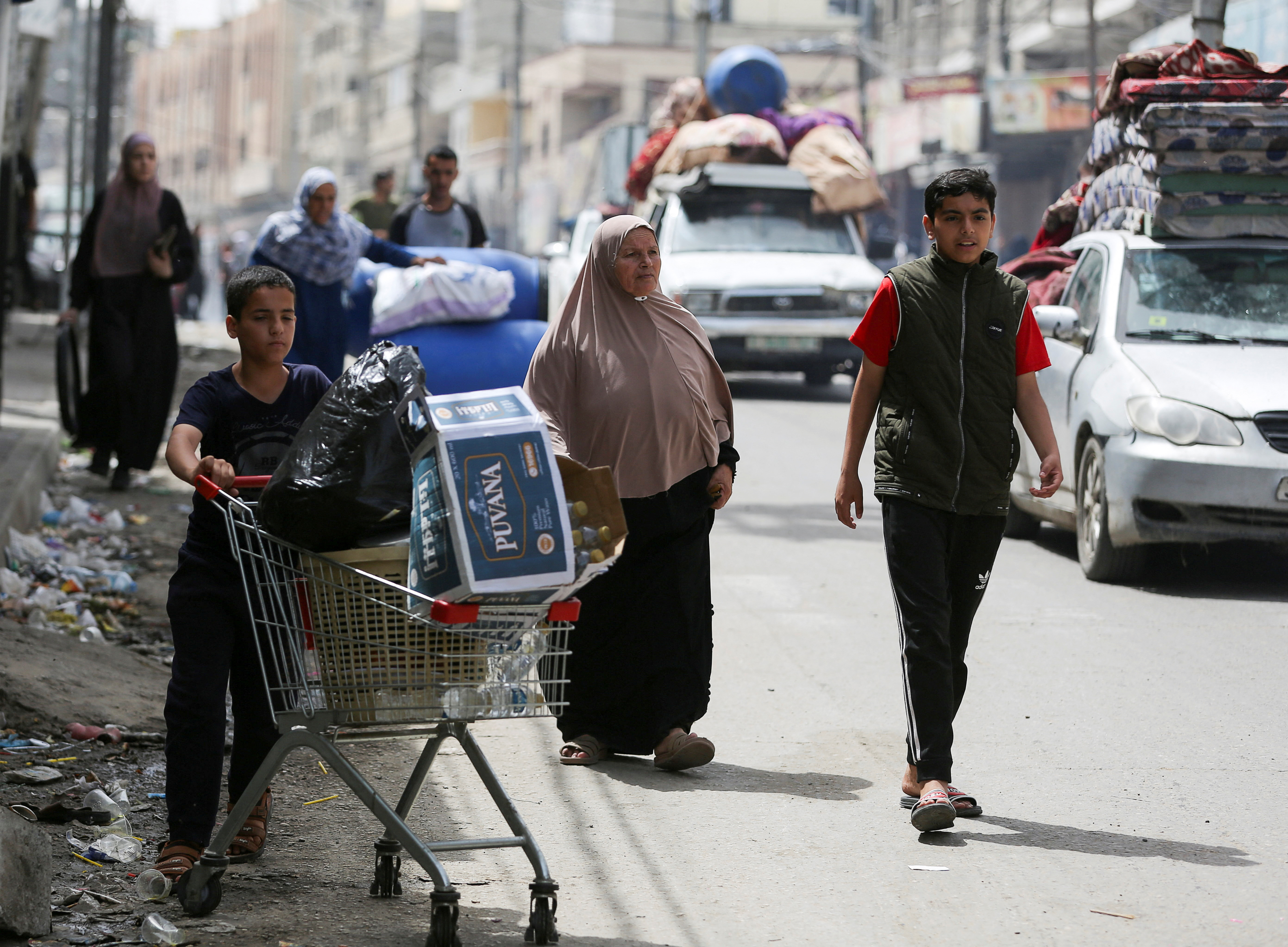 A Palestinian boy pushes a shopping trolley, as vehicles loaded with belongings evacuate, after Israeli forces launched a ground and air operation in the eastern part of Rafah, amid the ongoing conflict between Israel and Hamas, in Rafah, in the southern Gaza Strip, May 11