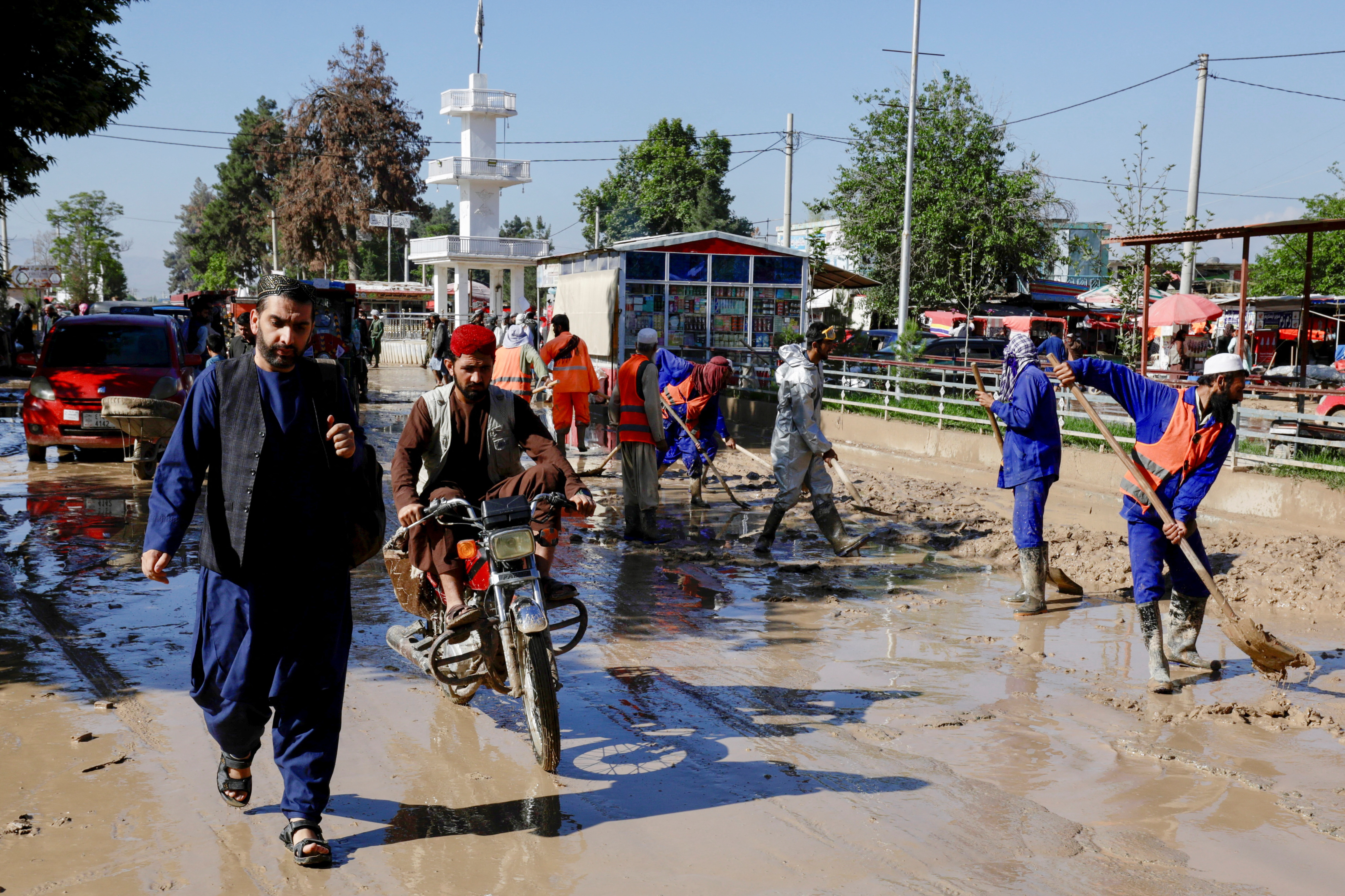 Traffic moves as municipality workers clear debris from the streets after flooding in Sheikh Jalal district, Baghlan province, Afghanistan May 12, 2024. REUTERS/Sayed Hassib