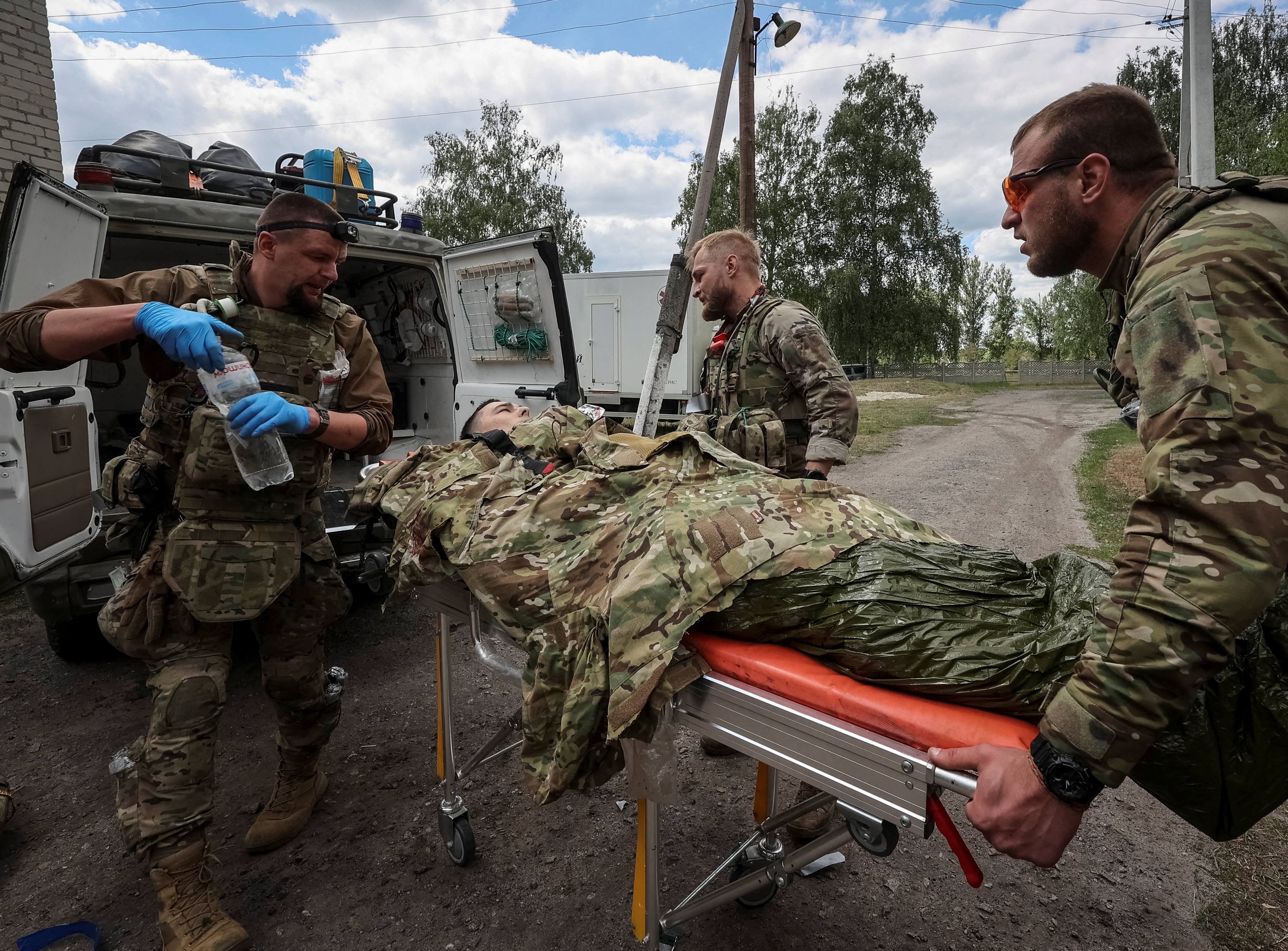Military paramedics treat a wounded Ukrainian service member, amid Russia's attack on Ukraine, near the town of Vovchansk in Kharkiv region, Ukraine May 12, 2024. REUTERS/Vyacheslav Madiyevskyy