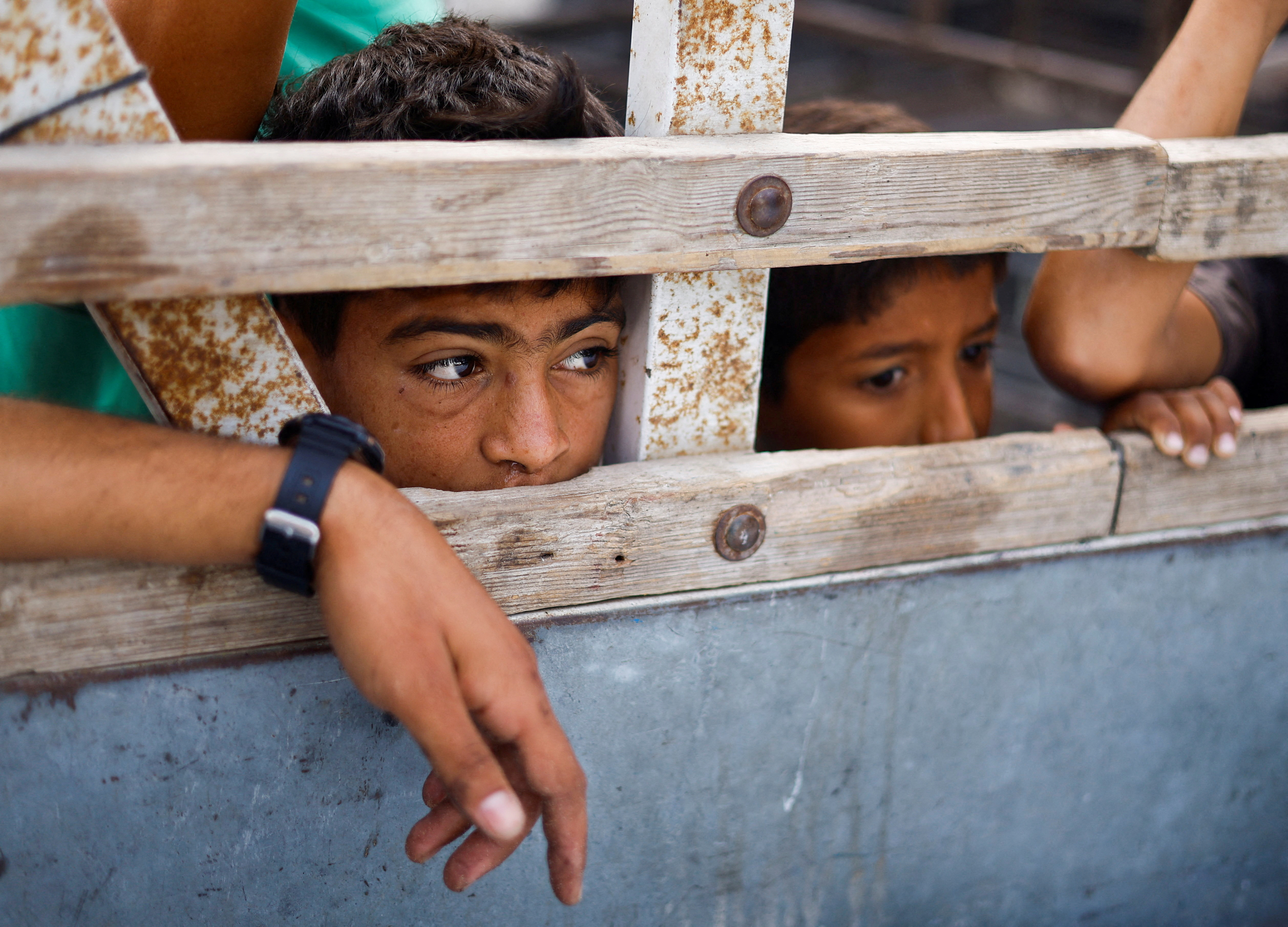 Children look into a vehicle carrying the bodies of Palestinians killed in an Israeli strike