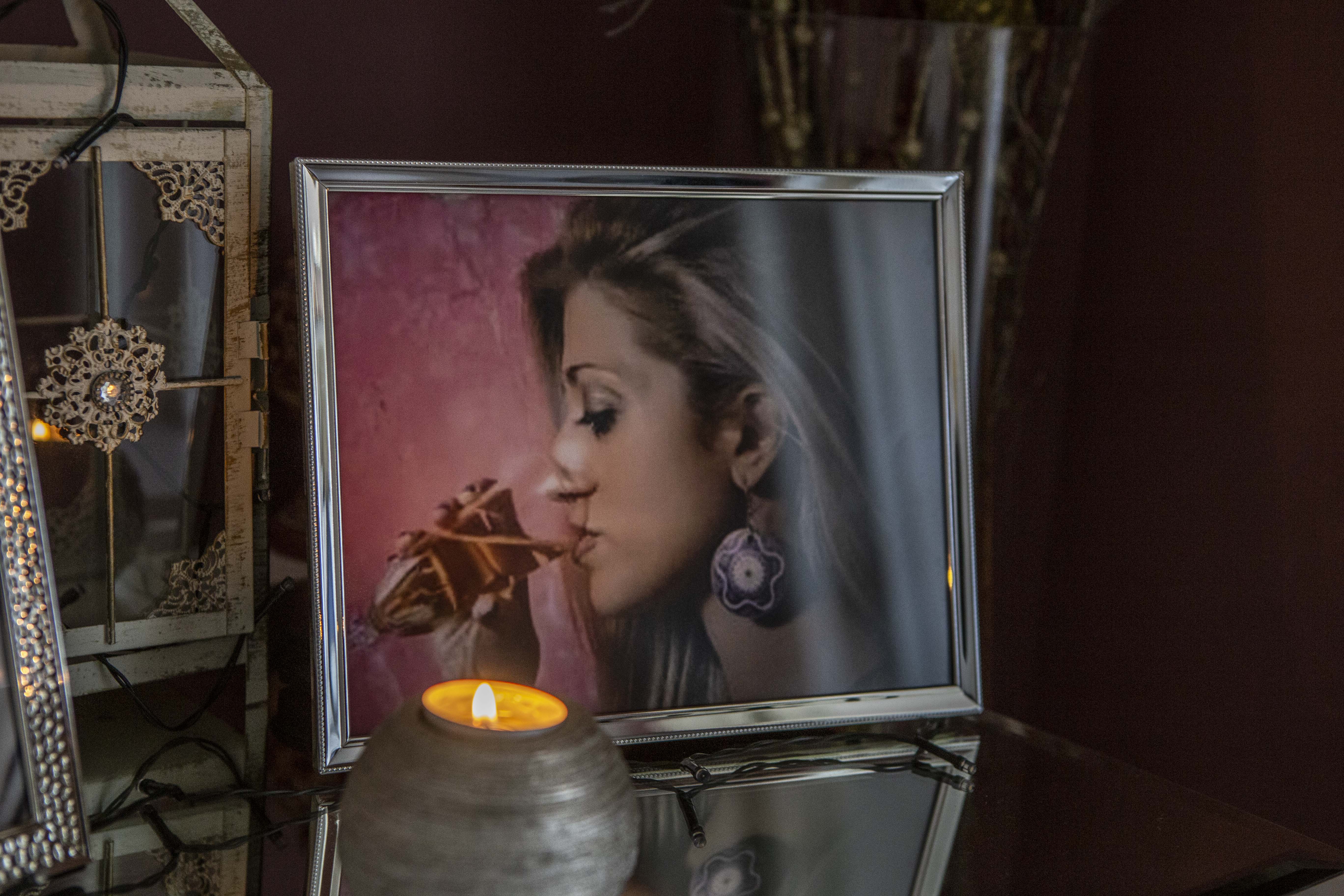 A framed photo ofDora next to a vigil lamp, a traditional Greek memorial practice for the dead.