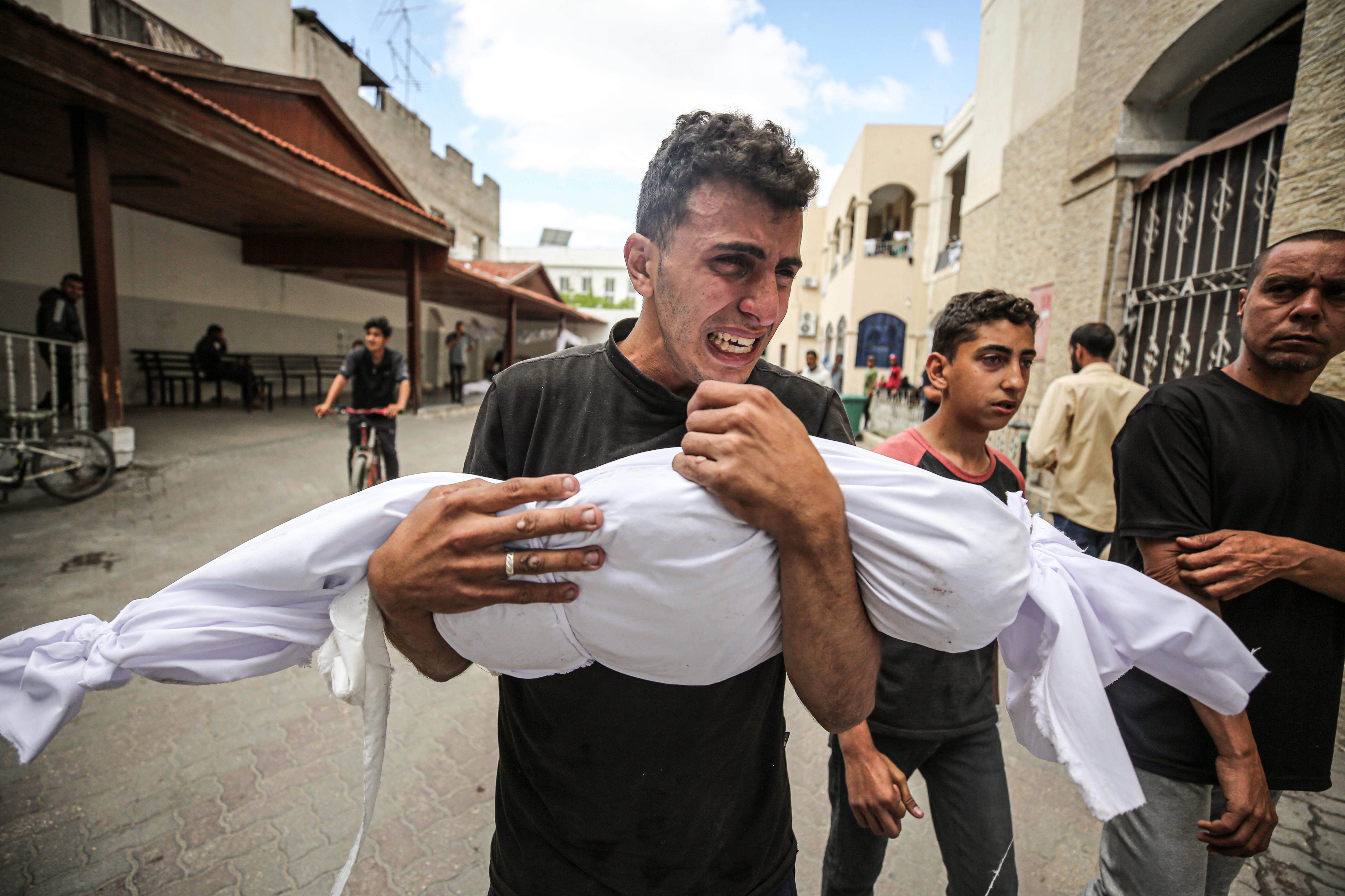 A Palestinian holds his relative killed in the Israeli attack