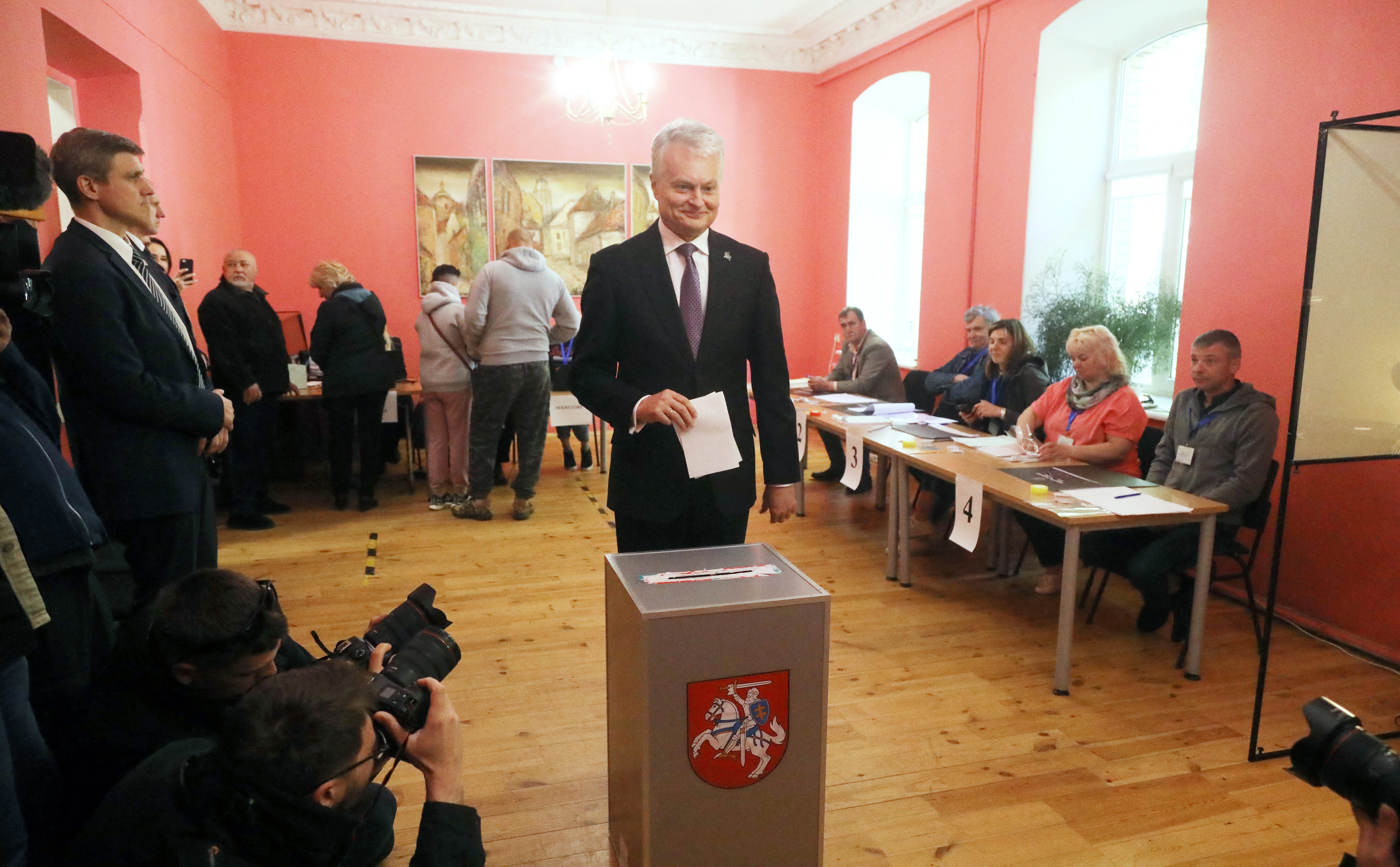Lithuania's President Gitanas Nauseda poses for photographers as he is about to cast his ballot during the first round of Lithuania's presidential election at a polling station in Vilnius