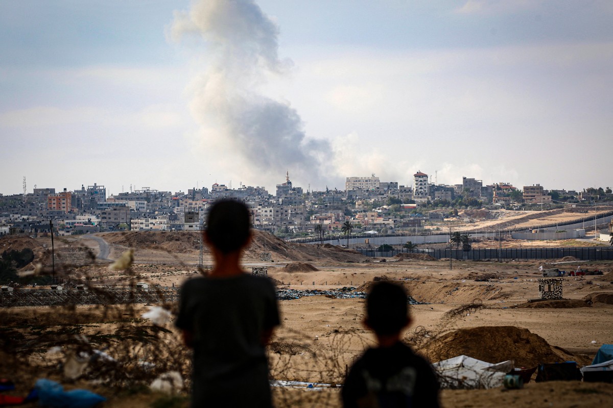 Boys watch smoke billowing during Israeli strikes east of Rafah