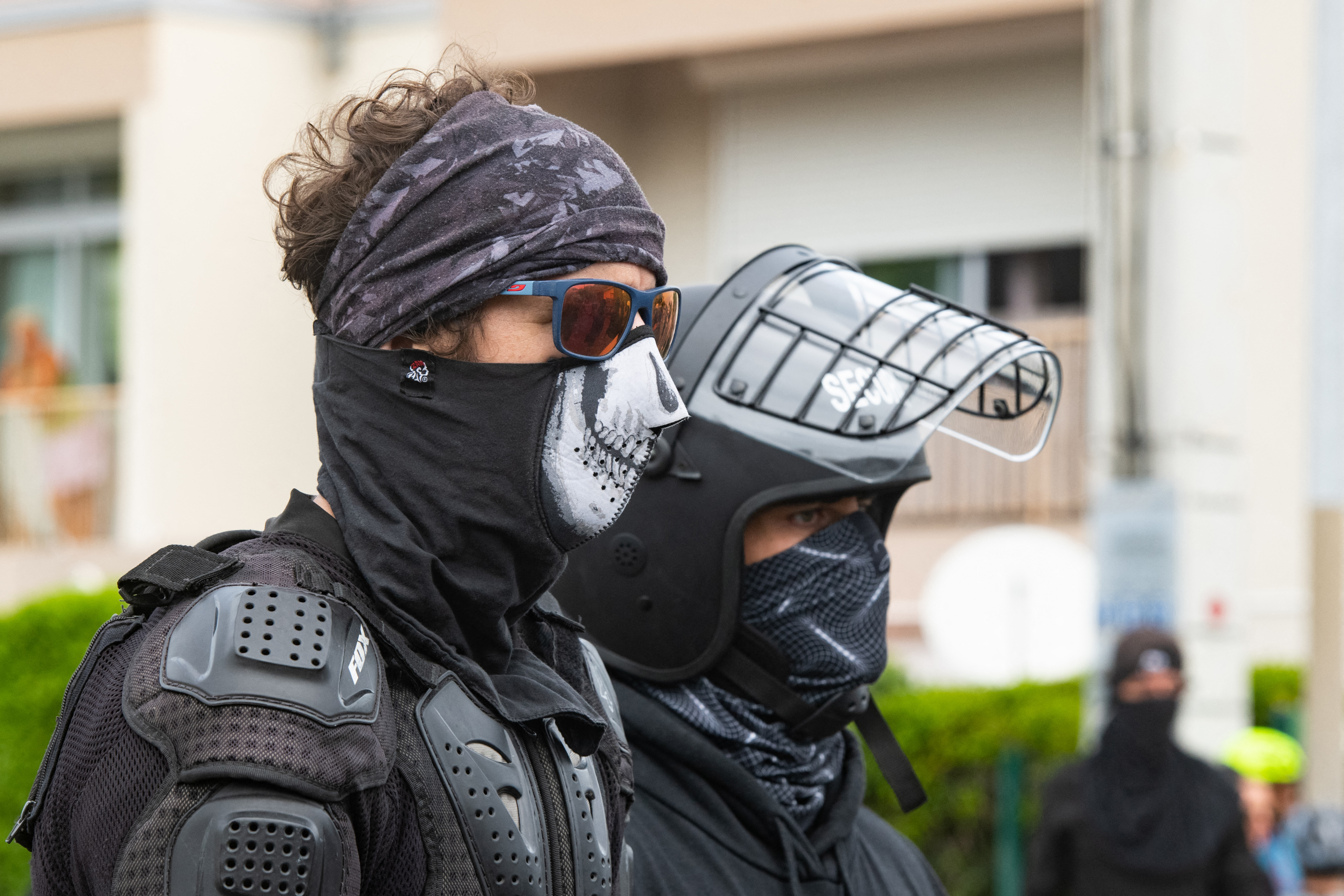 Masked residents keep an eye on activists at the entrance to Tuband, in the Motor Pool district of Noumea on May 15, 2024, amid protests linked to a debate on a constitutional bill aimed at enlarging the electorate for upcoming elections of the overseas French territory of New Caledonia.