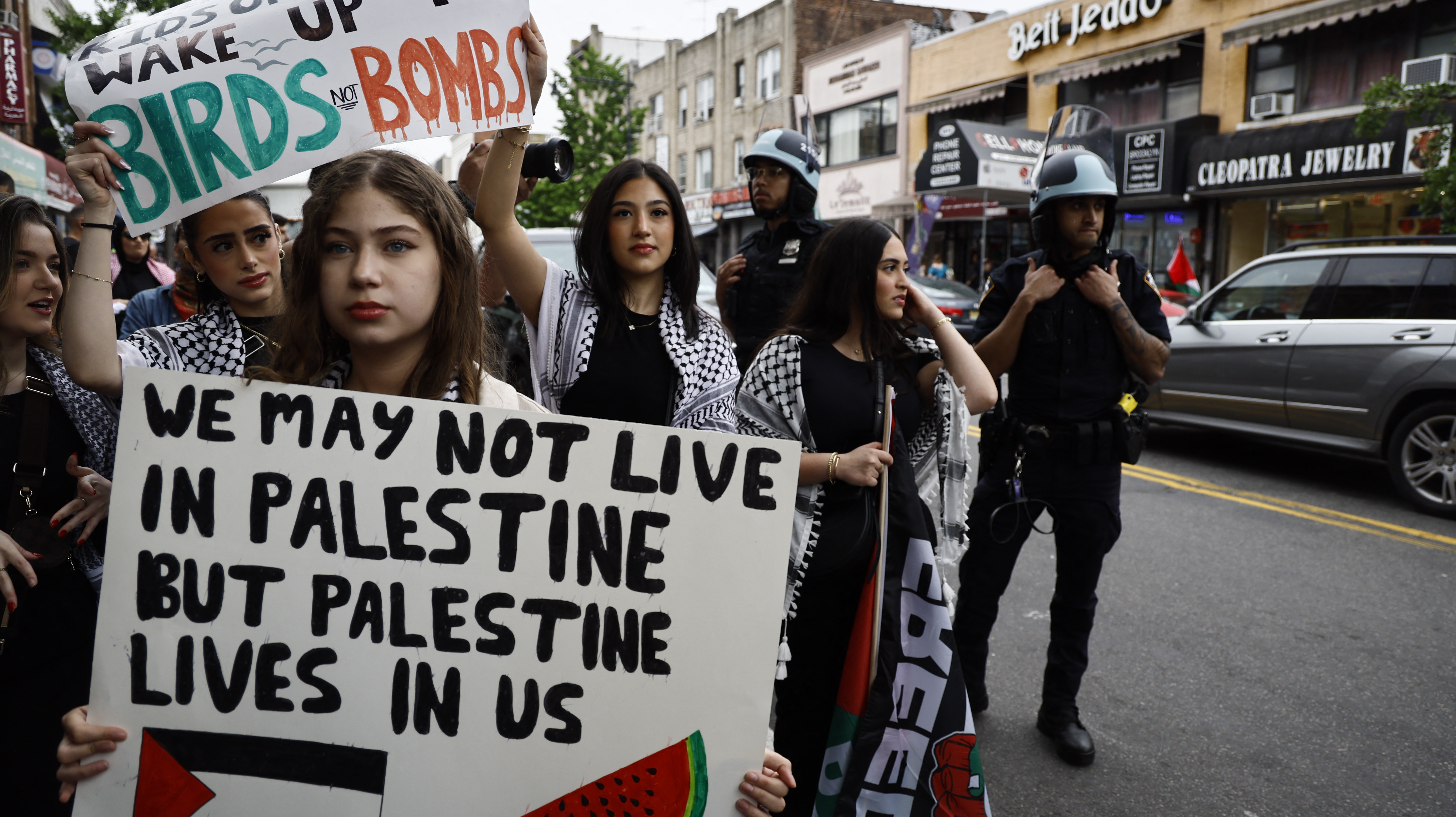 people hold palestinian flags at a protest