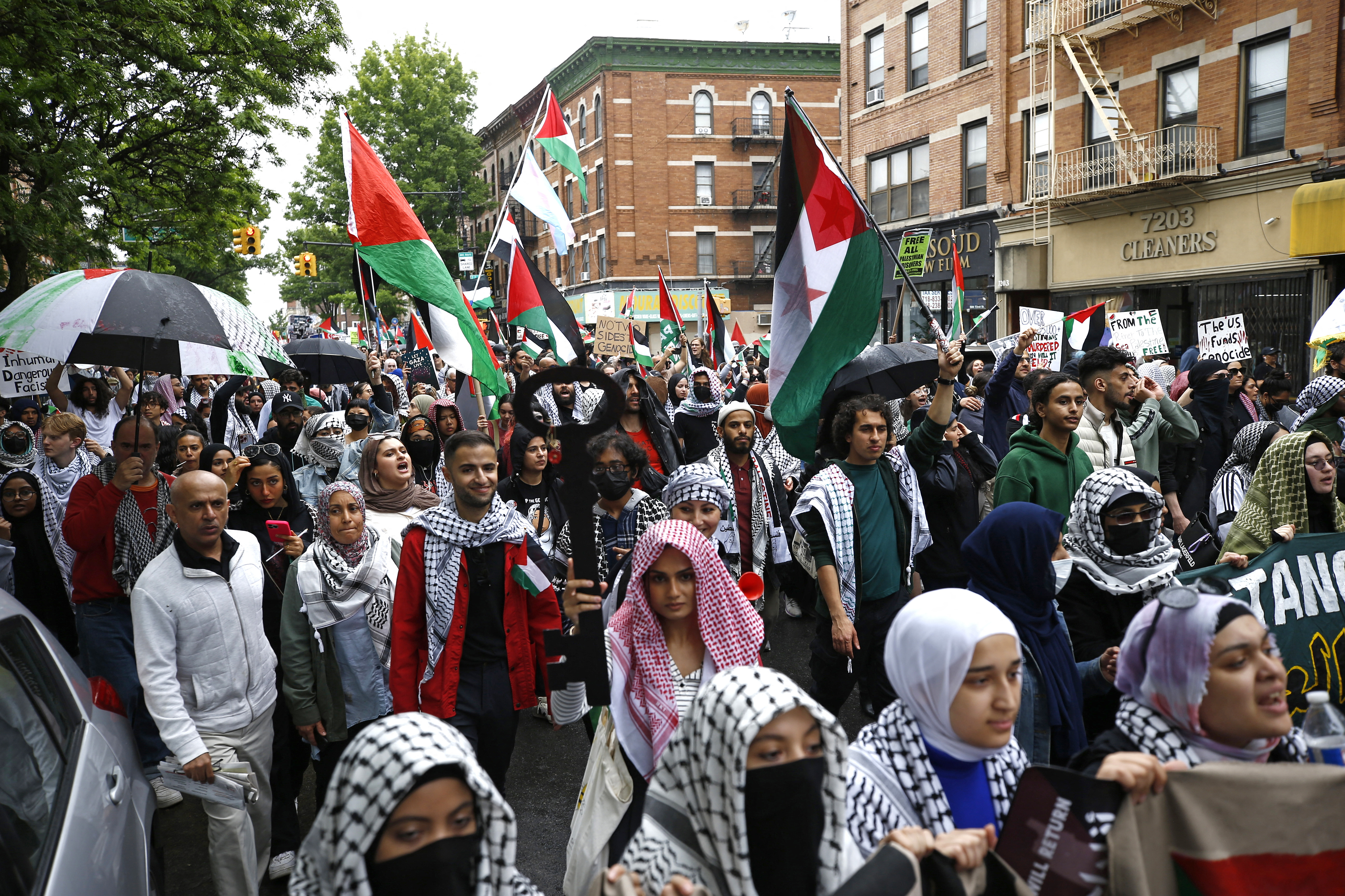 people hold palestinian flags at a protest