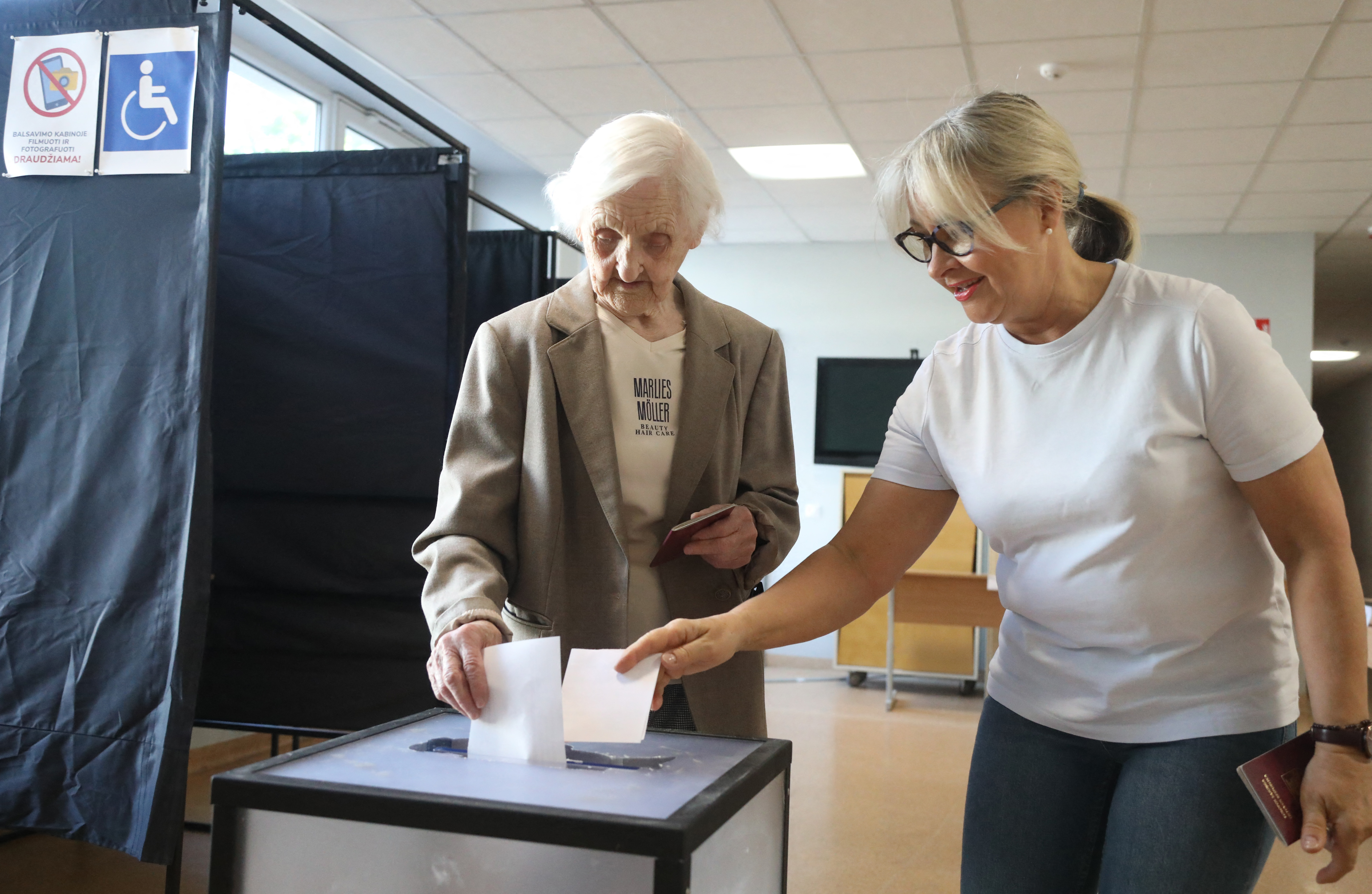 Voters in Lithuania cast their ballot during the second round of the presidential election at a polling station in capital Vilnius