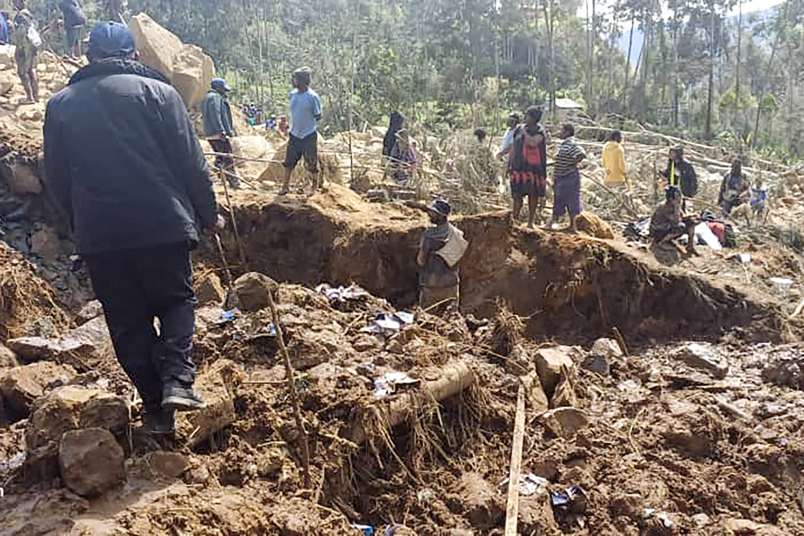 This handout photo taken and received on May 29, 2024 courtesy of Nickson Pakea, president of Porgera Chamber of Commerce and Industry, shows locals digging at the site of a landslide at Yambali village in the region of Maip Mulitaka, in Papua New Guinea's Enga Province. (Photo by NICKSON PAKEA / PRESIDENT OF PORGERA CHAMBER OF COMMERCE AND INDUSTRY / AFP) / NO USE AFTER JUNE 29, 2024 01:48:42 GMT - RESTRICTED TO EDITORIAL USE - MANDATORY CREDIT "AFP PHOTO / PRESIDENT OF PORGERA CHAMBER OF COMMERCE AND INDUSTRY / NICKSON PAKEA" - NO MARKETING NO ADVERTISING CAMPAIGNS - DISTRIBUTED AS A SERVICE TO CLIENTS - NO ARCHIVE