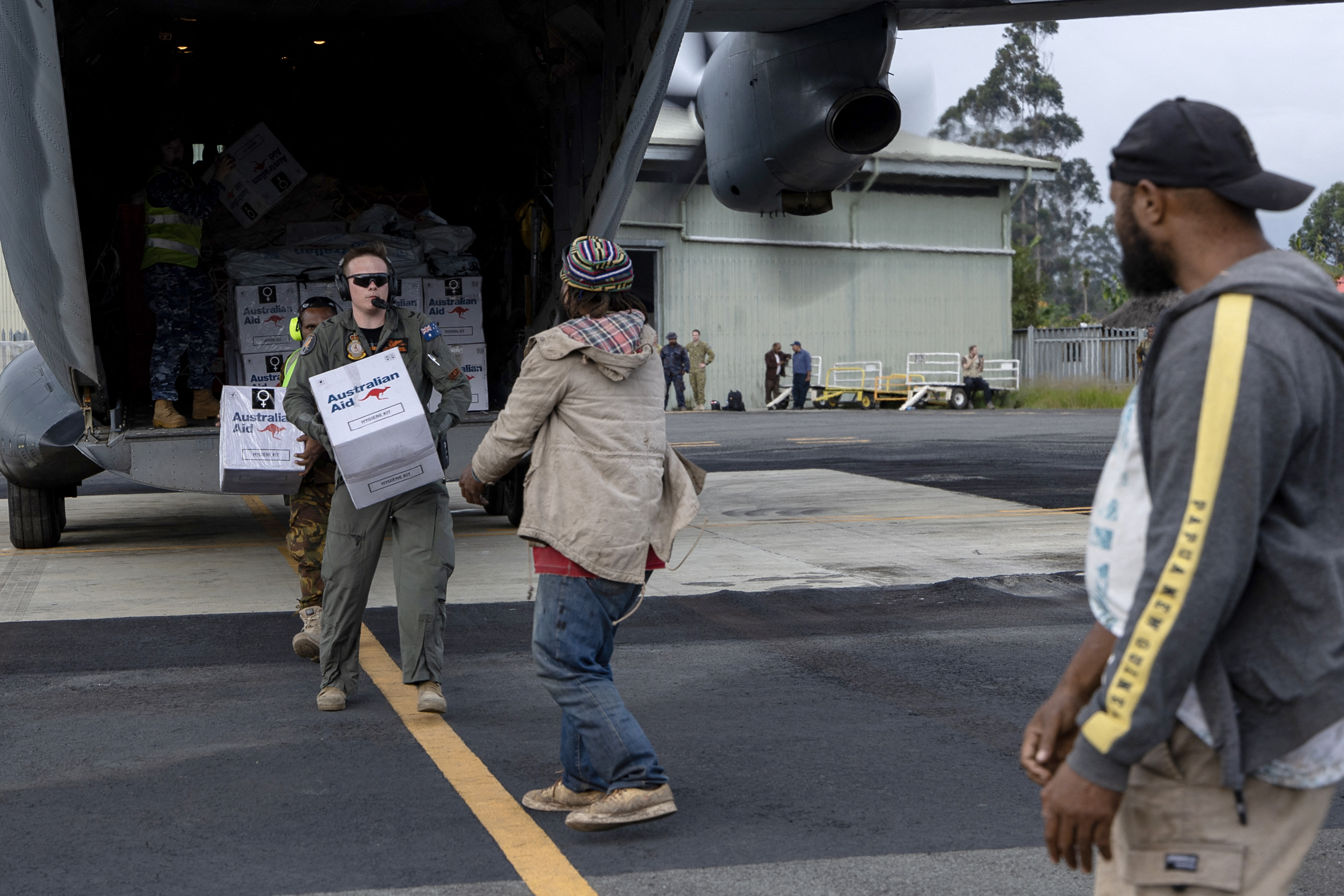 This handout photo taken on May 29, 2024 and received on May 30, 2024 from the Australian Defence Force shows a members of the ground staff unloading aid from a Royal Australian Air Force aircraft at Wapenamanda Airport near the site of the landslide in Yambali village, in Papua New Guinea's Enga Province. (Photo by Handout / Australian Defence Force / AFP) / RESTRICTED TO EDITORIAL USE - MANDATORY CREDIT "AFP PHOTO / AUSTRALIAN DEFENCE FORCE” - NO MARKETING NO ADVERTISING CAMPAIGNS - DISTRIBUTED AS A SERVICE TO CLIENTS
