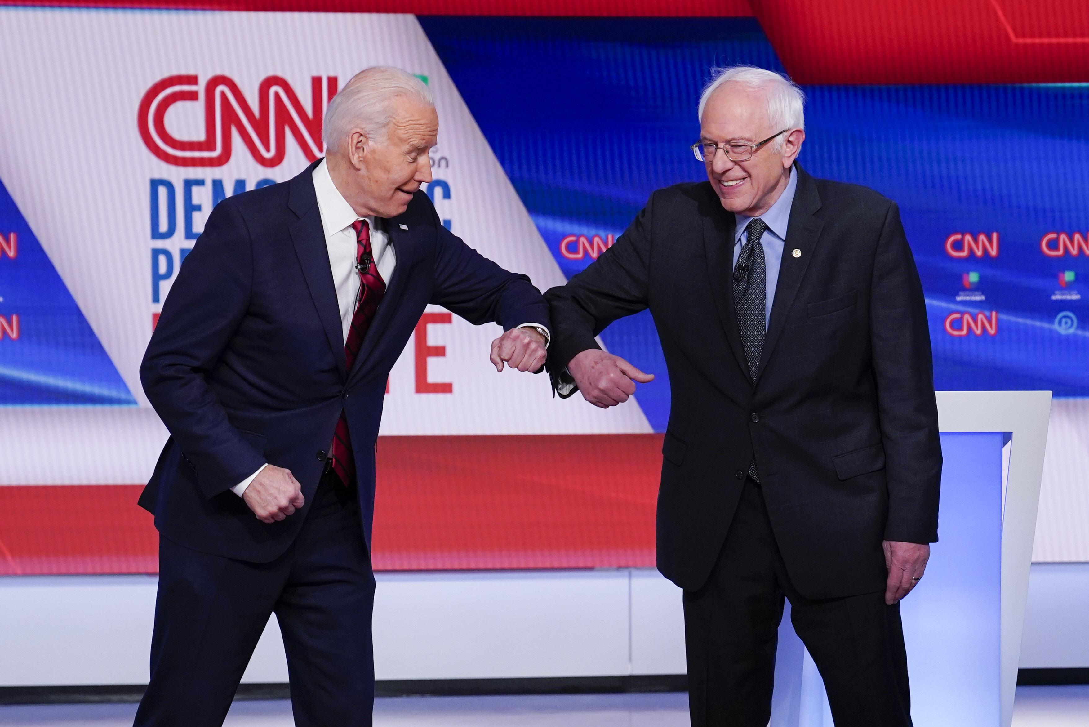 Joe Biden and Bernie Sanders rub elbows on stage at a CNN debate.