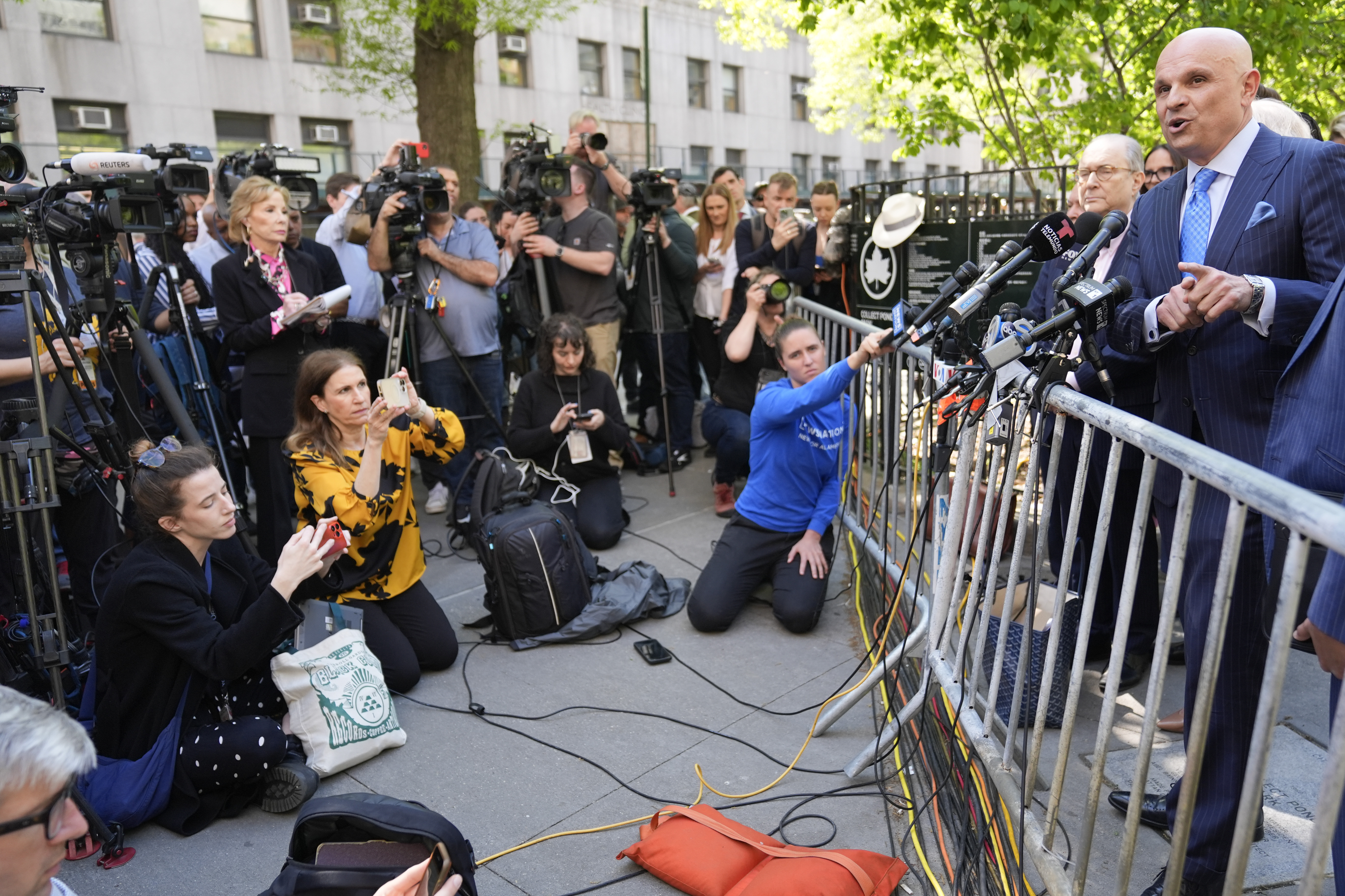 Arthur Aidala speaks to reporters behind a metal barricade outside in New York.