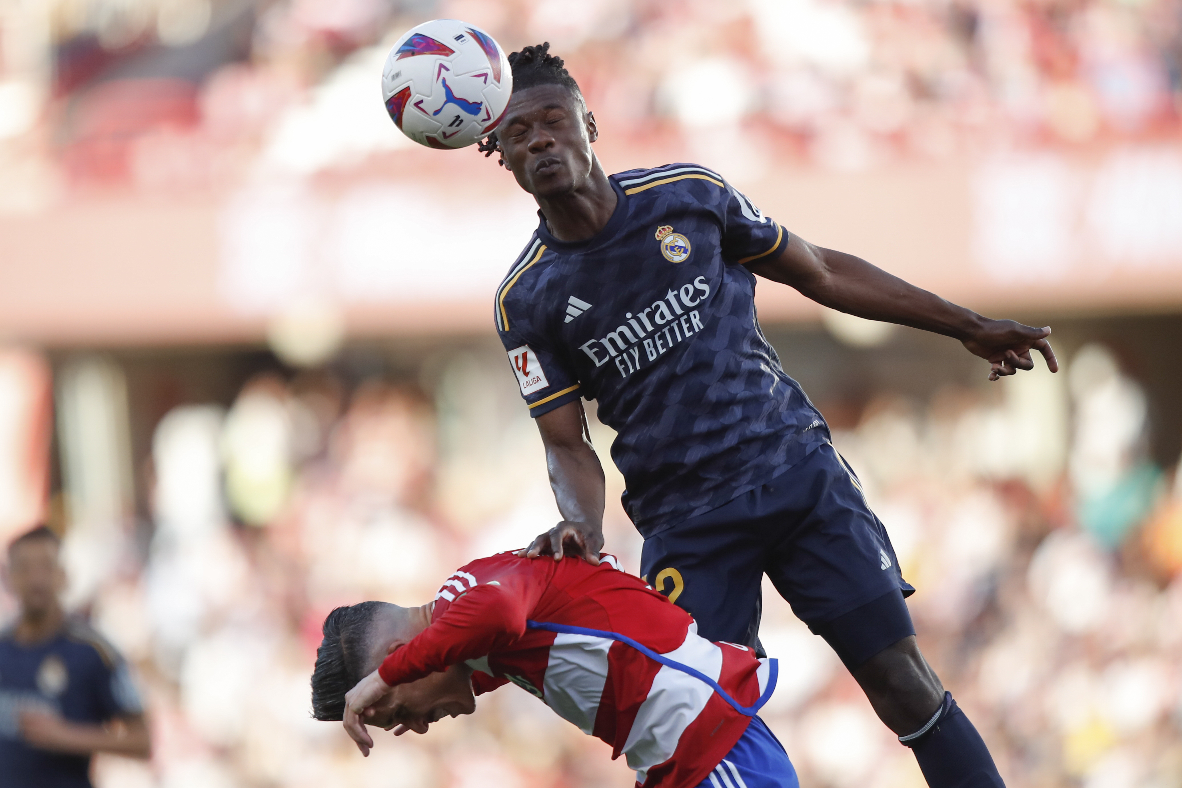 Real Madrid's Eduardo Camavinga, top, heads the ball challenged by Granada's Jose Callejon during a Spanish La Liga soccer match between Granada FC and Real Madrid at Los Carmanes stadium in Granada, Spain, Saturday, May 11, 2024. (AP Photo/Fermin Rodriguez)