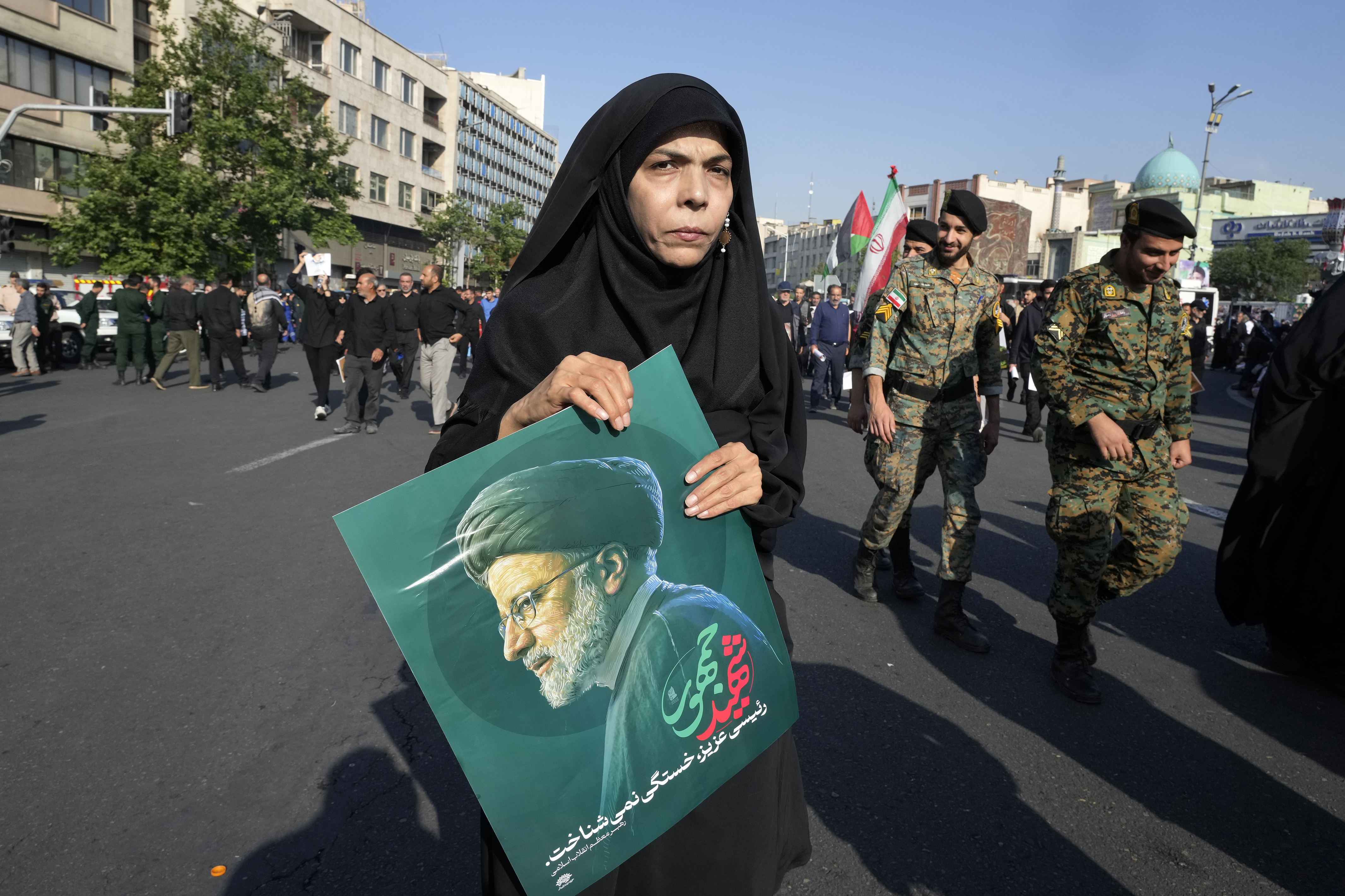 A woman holds a poster of the late Iranian President Ebrahim Raisi 