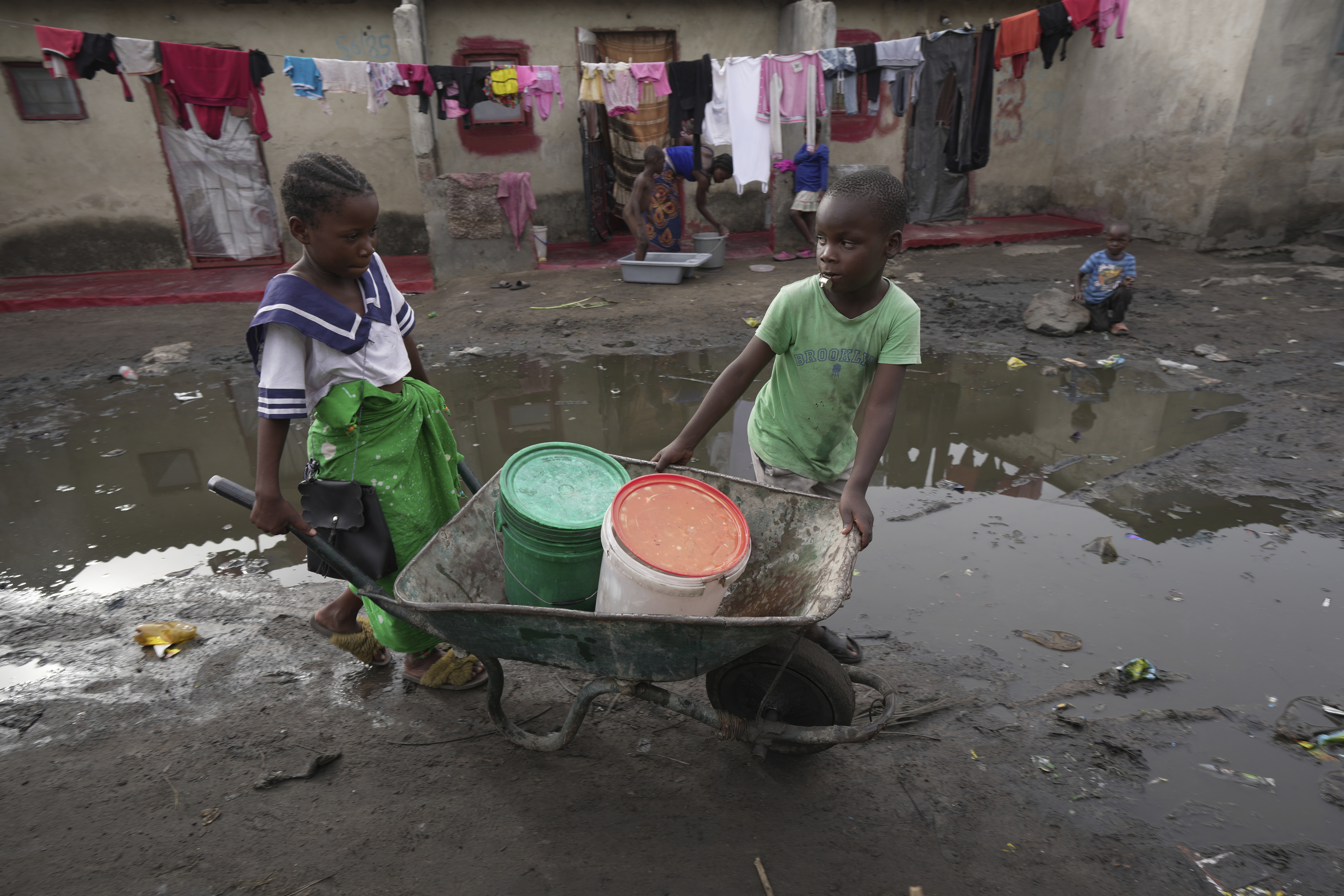 Children fetch water using a wheelbarrow in Lilanda township in Lusaka, Zambia