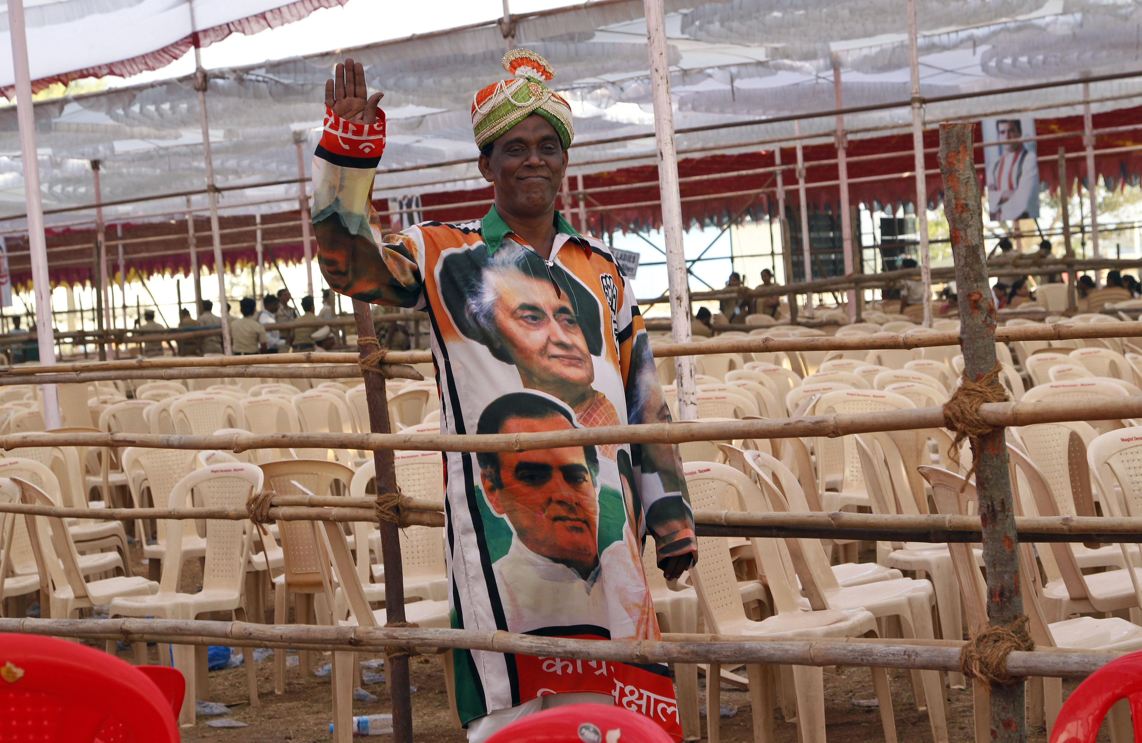 FILE - In this Thursday, March 6, 2014 file photo, a supporter of Indias Congress party wearing an outfit with portraits of former Indian Prime Ministers Indira Gandhi, top, and Rajiv Gandhi, waves to camera at an election campaign rally addressed by the party vice president and scion of the Nehru-Gandhi family Rahul Gandhi in Thane, on the outskirts of Mumbai, India. In an election campaign led by Rahul Gandhi - the son, grandson, and great-grandson of Indian prime ministers - the Indian National Congress party suffered the most crushing defeat in its 128-year history Friday when the results of India's general election were released. (AP Photo/Rajanish Kakade, File)
