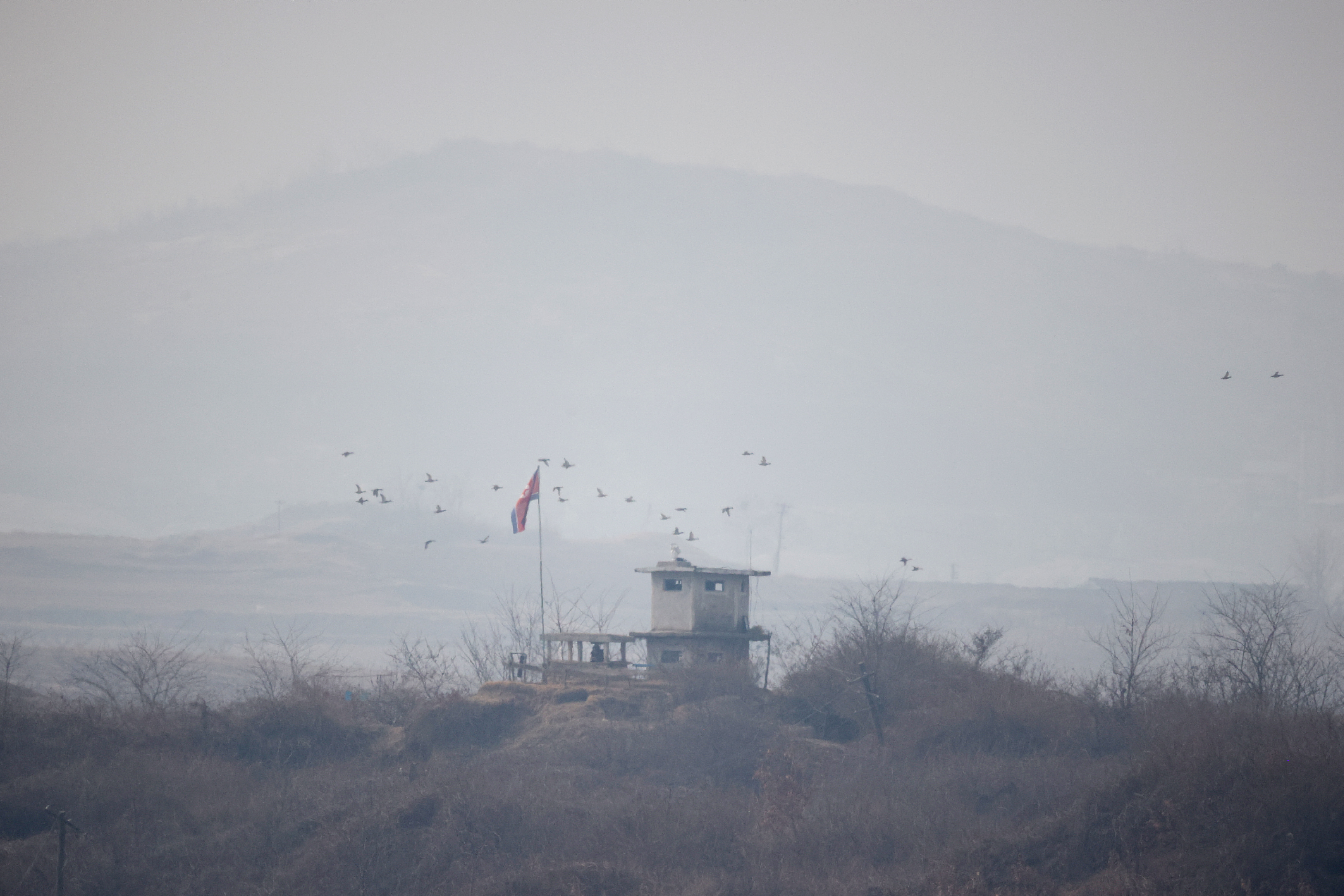 A view of a North Korean guard post in the DMZ. There are birds flying about