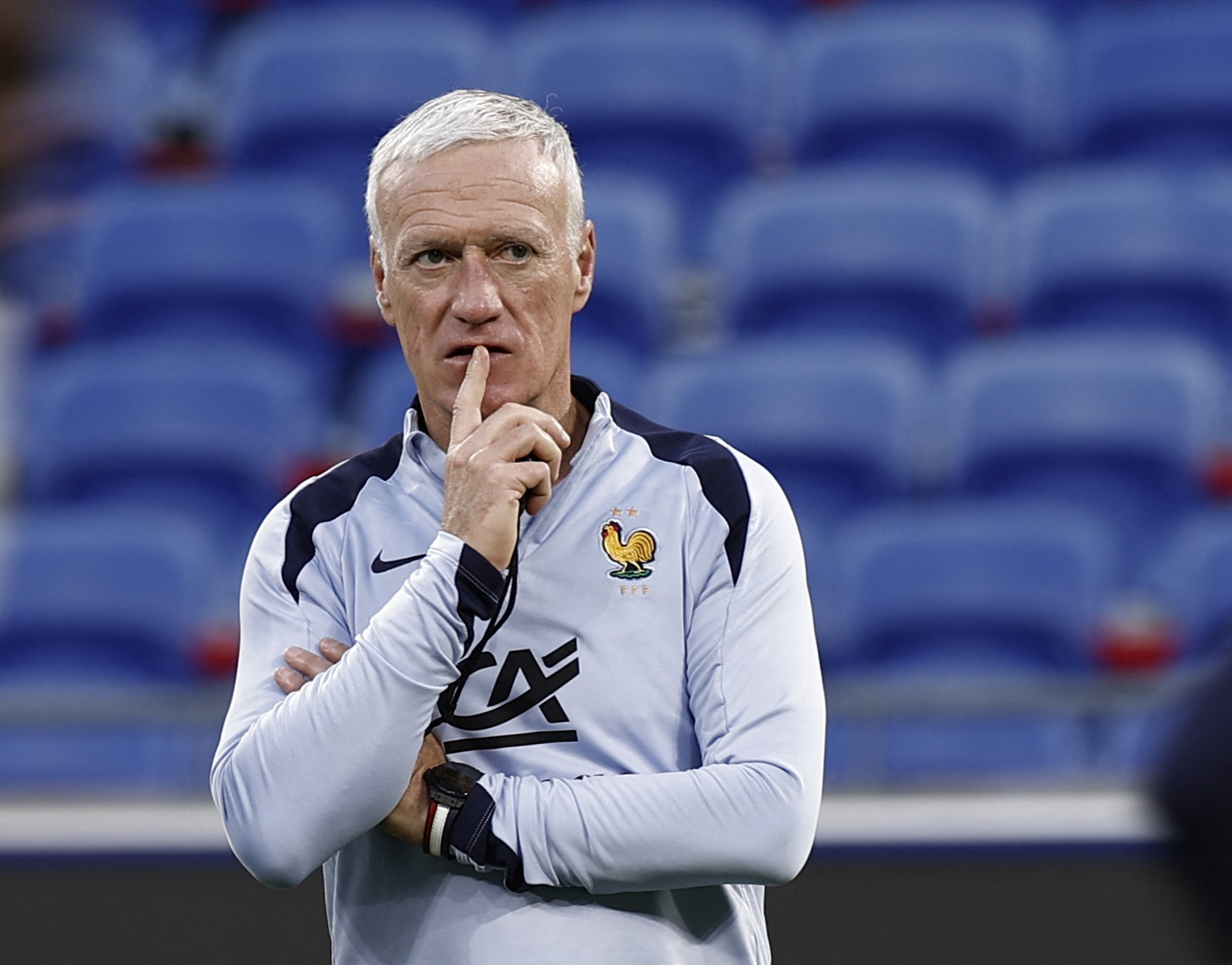 Football manager watches team train.