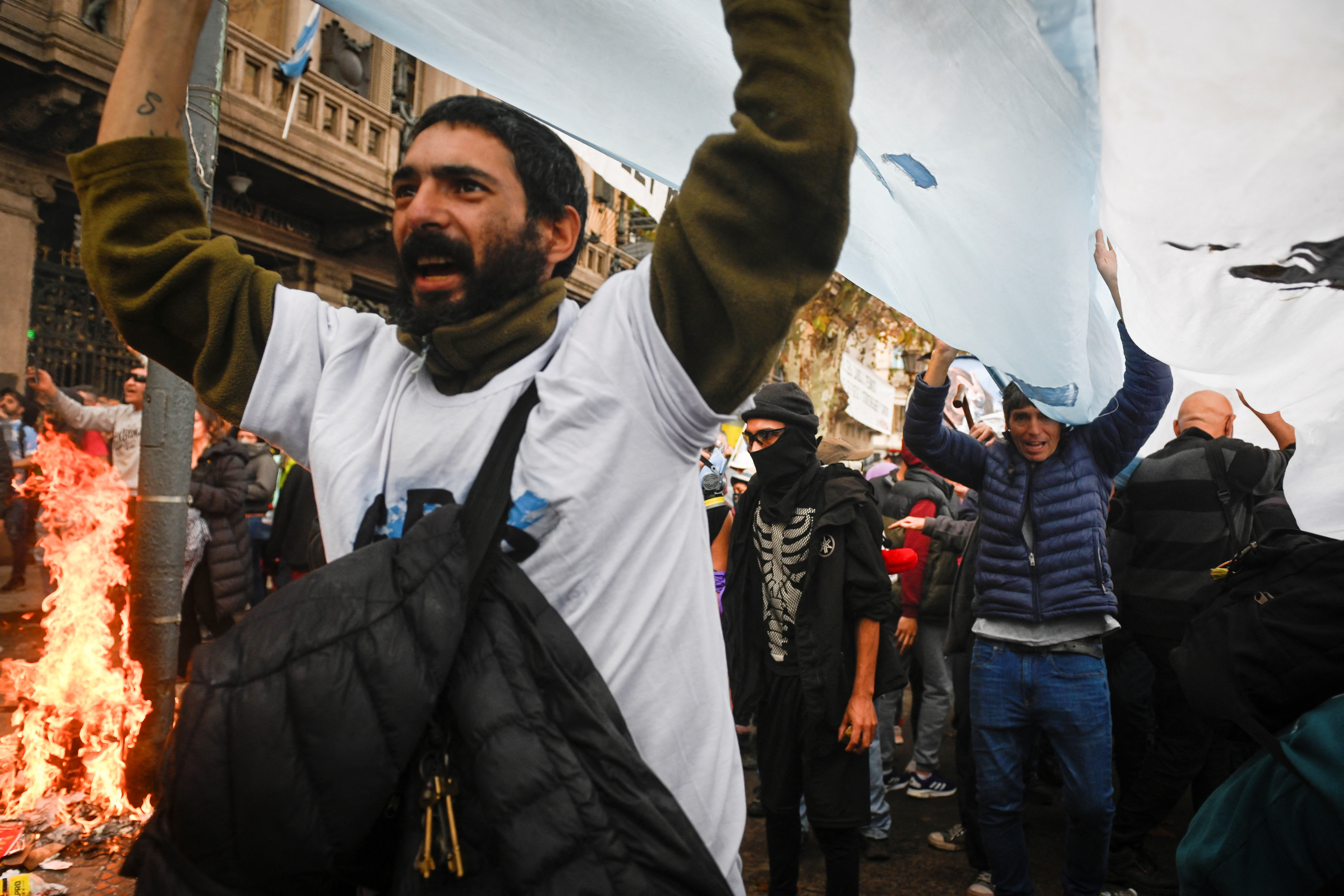 A protester raises a flag or banner above his head as he marches down the streets of Buenos Aires.