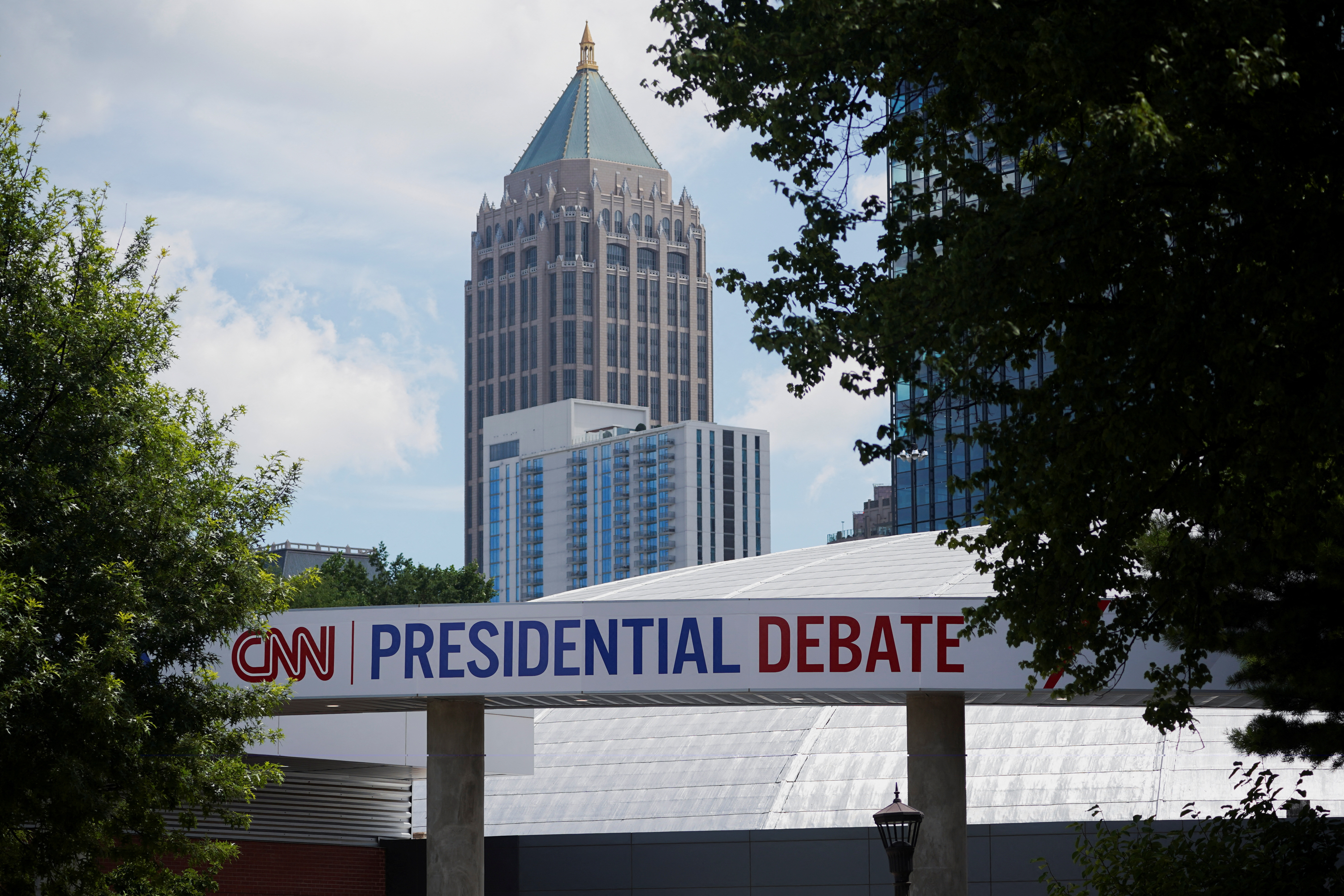 A tower in downtown Atlanta is in the background, while a sign in the foreground advertises the CNN Presidential Debate.