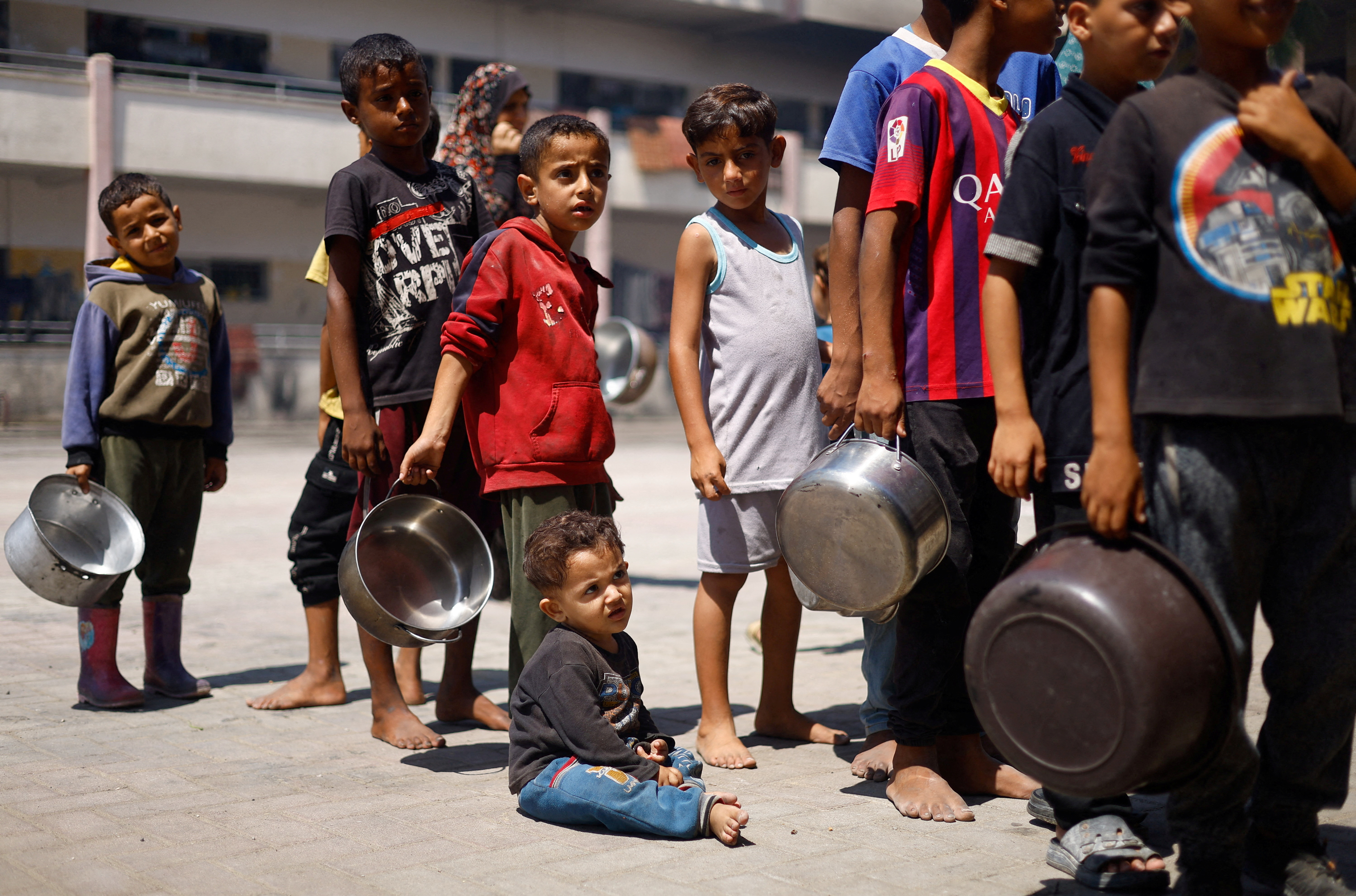 Palestinians gather to receive food cooked by a charity kitchen, amid food scarcity