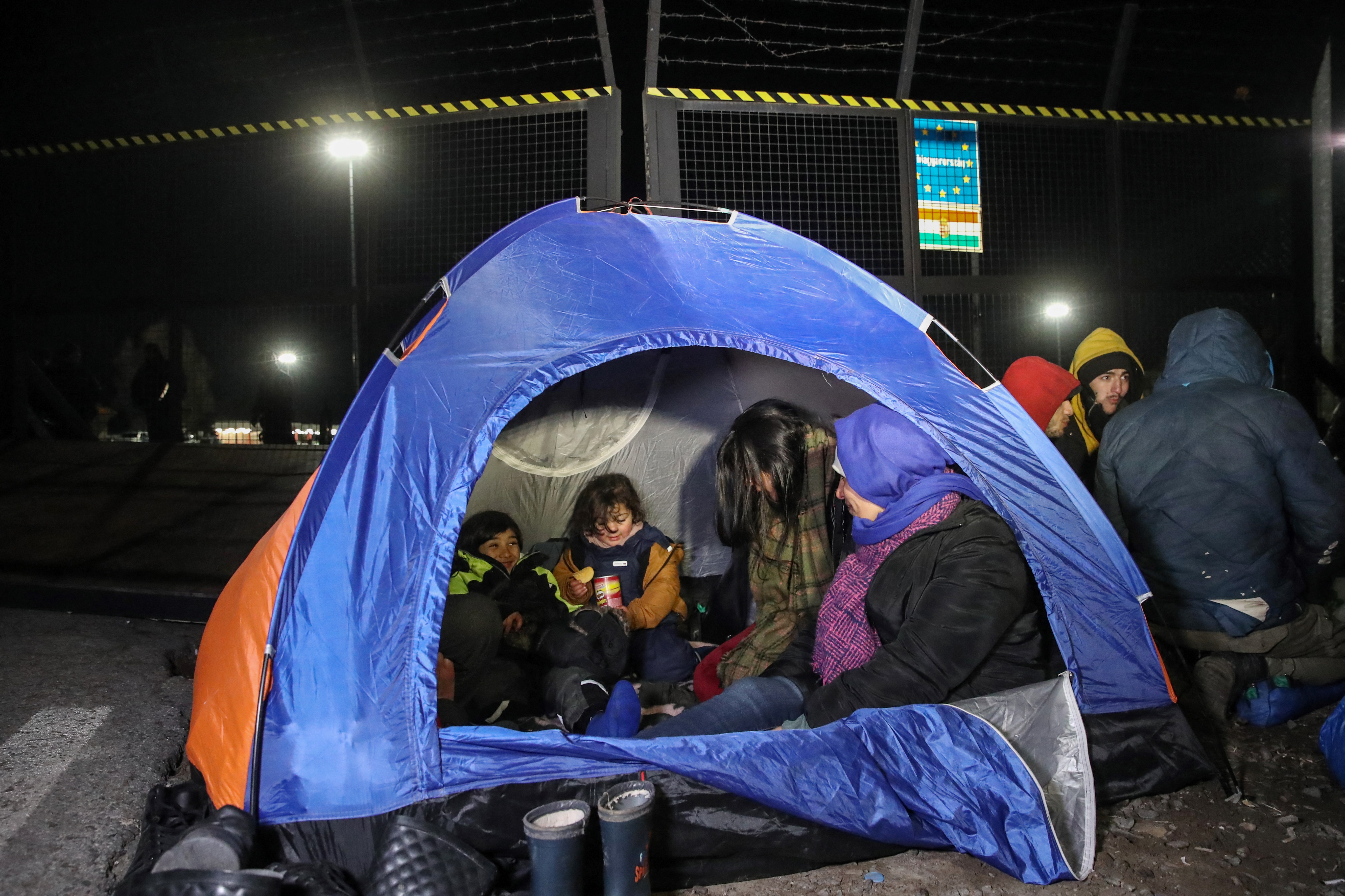 Migrants camp in tents next to the border fence at the Serbian Kelebija border village near Subotica on February 6, 2020, as the Tompa road border-crossing on the Hungarian side has been temporarily closed by the Hungarian police. Hungarian police temporarily closed a Serbian border crossing on February 6 after a large migrant group showed up there and demanded to be let in. The attempt came a week after 60-70 people tried to get into Hungary at another Serbian border crossing under cover of night, prompting security staff to fire warning shots in the air. Hungarian police report a sharp rise in attempts to cross the country's southern borders since December. / AFP / ISTVAN HUSZTI