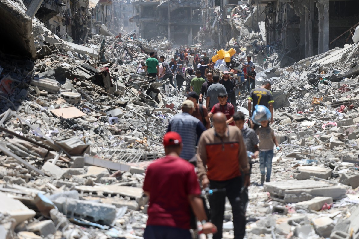 Palestinians carry some salvaged belongings as they leave the Jabalia refugee camp in the northern Gaza Strip