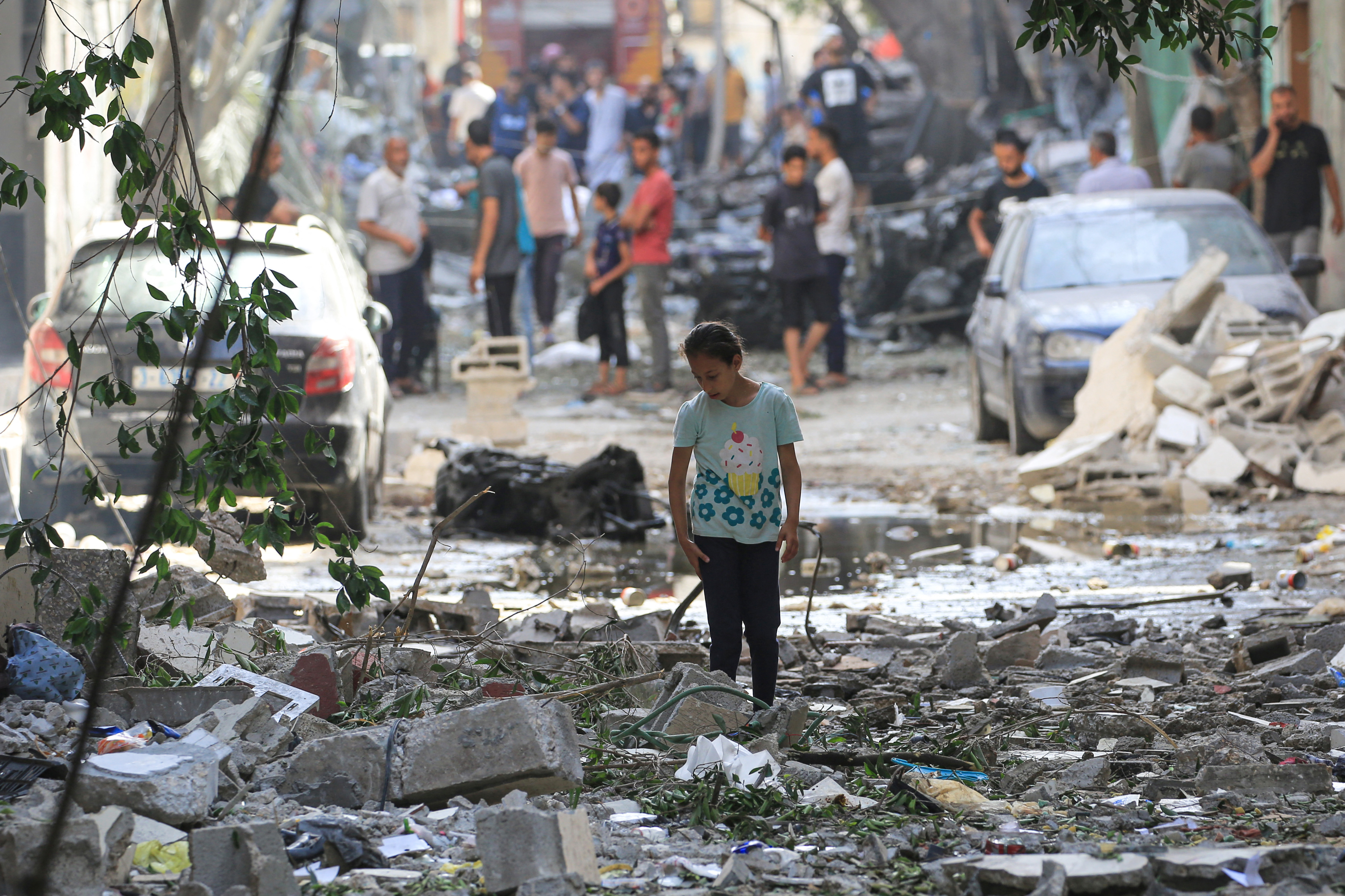 A Palestinian girls walks amidst the debris a day after an operation by the Israeli Special Forces in the Nuseirat camp, in the central Gaza Strip on June 9