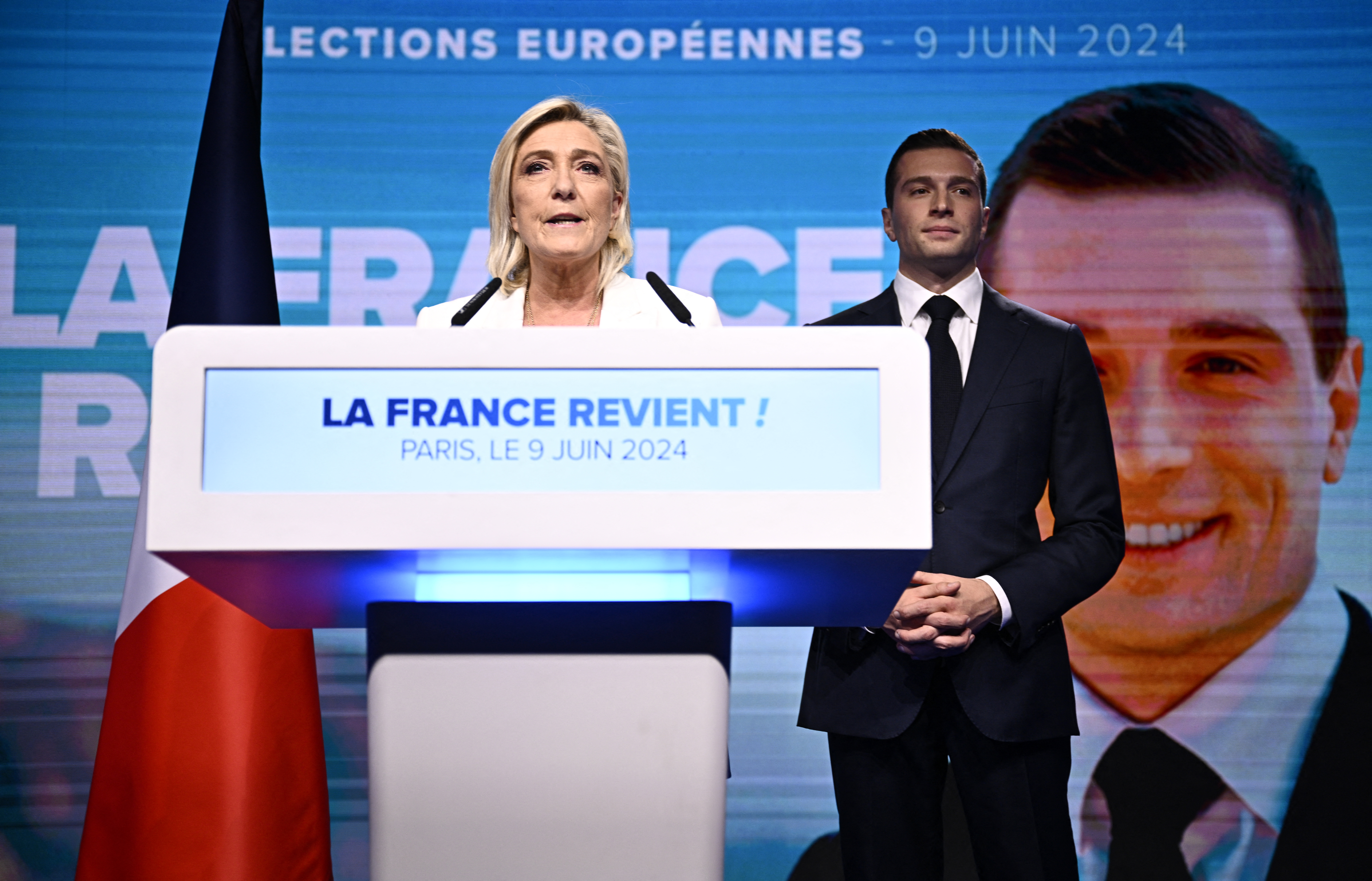 French far-right Rassemblement National (RN) party leader Marine Le Pen (L) addresses militants as party President Jordan Bardella listens after French President announced he is calling for new general elections on June 30