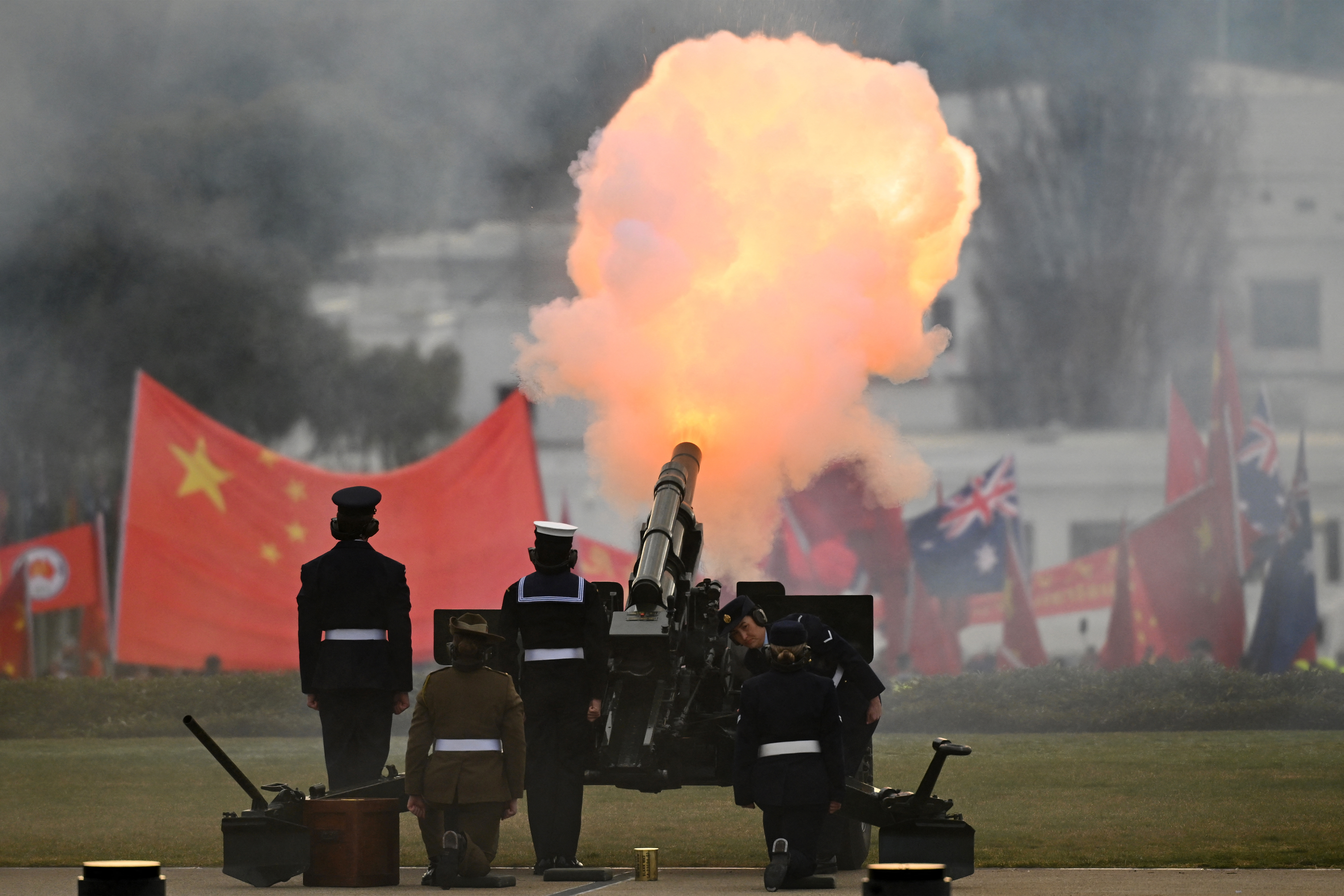A gun salute at parliament in Canberra. Tere is a large cloud of smoke and flame.