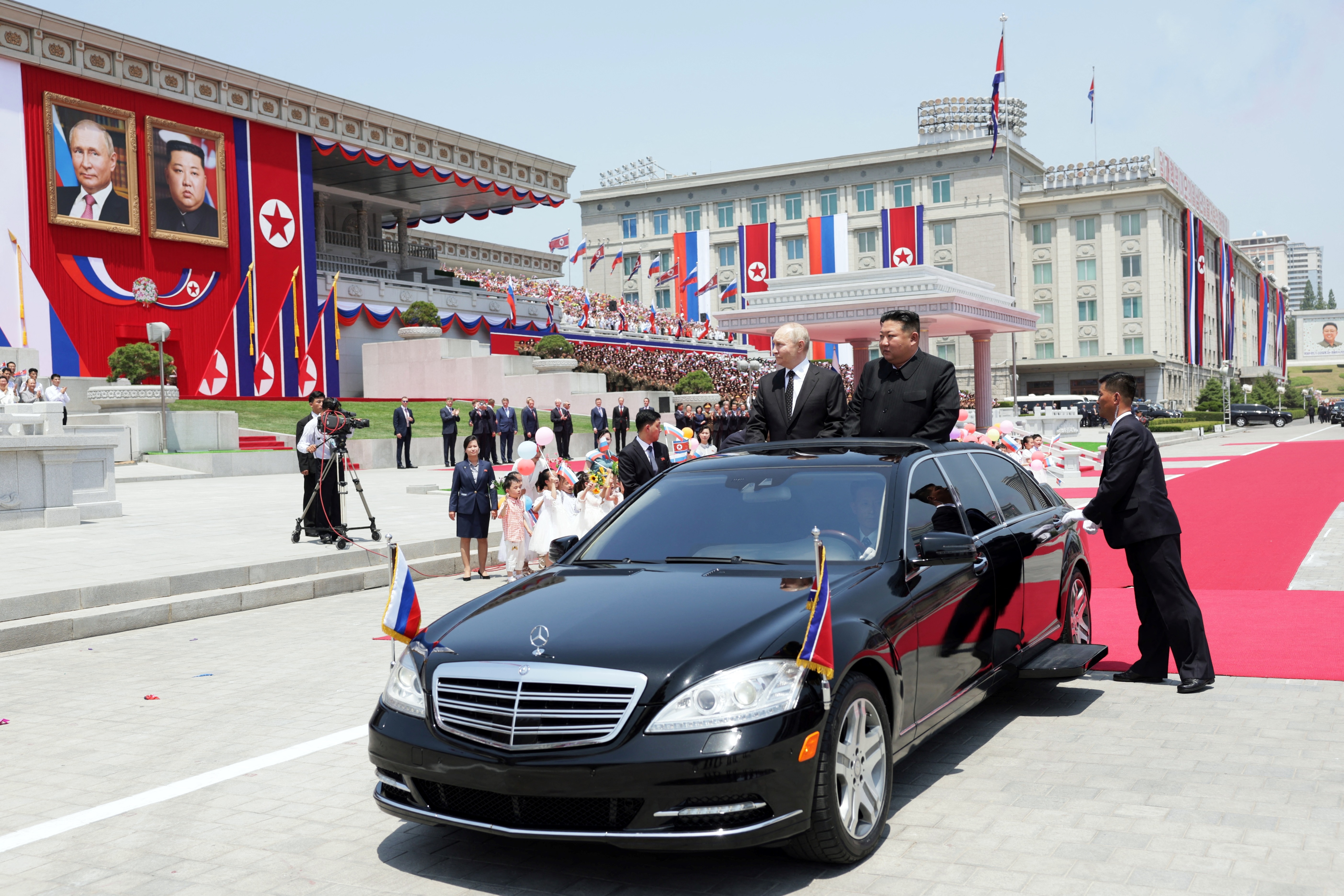 In this pool photograph distributed by the Russian state agency Sputnik, North Korea's leader Kim Jong Un (R) and Russian President Vladimir Putin attend a welcoming ceremony at Kim Il Sung Square in Pyongyang on June 19, 2024. - Russian President Vladimir Putin landed in North Korea early on June 19, the Kremlin said, kicking off a visit set to boost defence ties between the two nuclear-armed countries as Moscow pursues its war in Ukraine. (Photo by Gavriil GRIGOROV / POOL / AFP) / -- EDITOR'S NOTE : THIS IMAGE IS DISTRIBUTED BY THE RUSSIAN STATE OWNED AGENCY SPUTNIK --