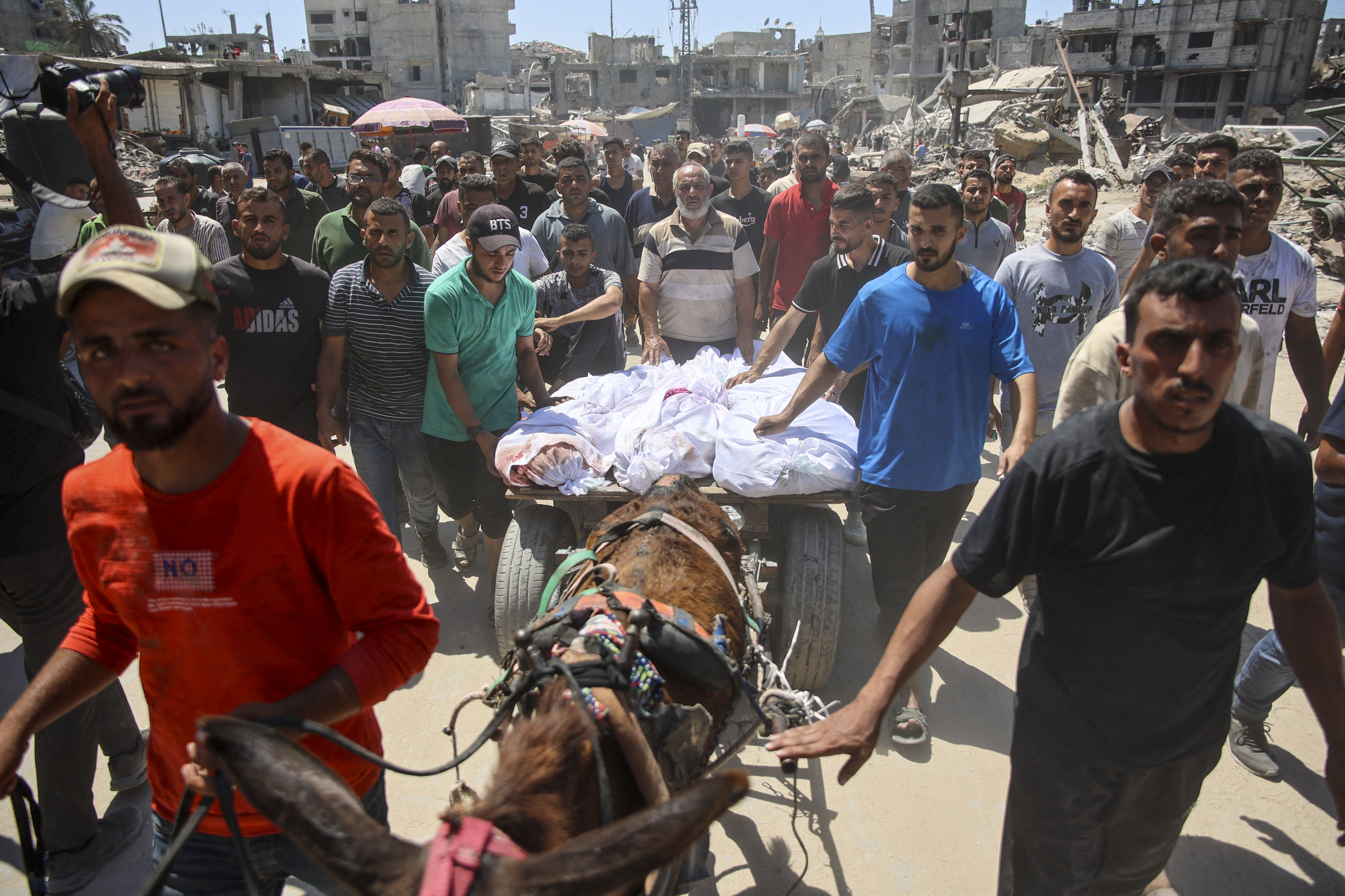 Palestinians transport the bodies of loved ones killed during Israeli bombardment for burial in al-Tuffah neighbourhood in Gaza City on June 22