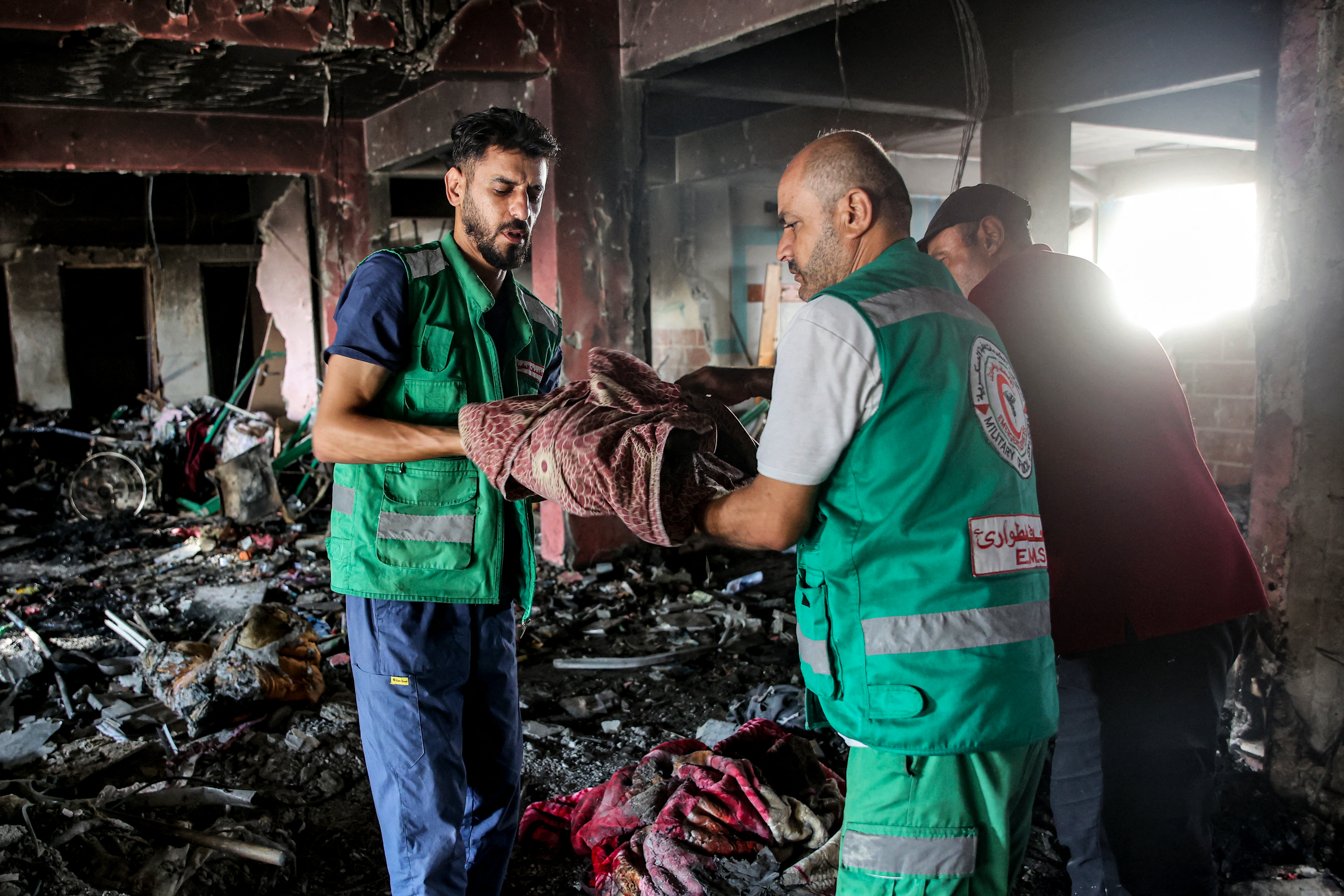 Paramedics retrieve the body of a child killed in the aftermath of overnight Israeli bombardment