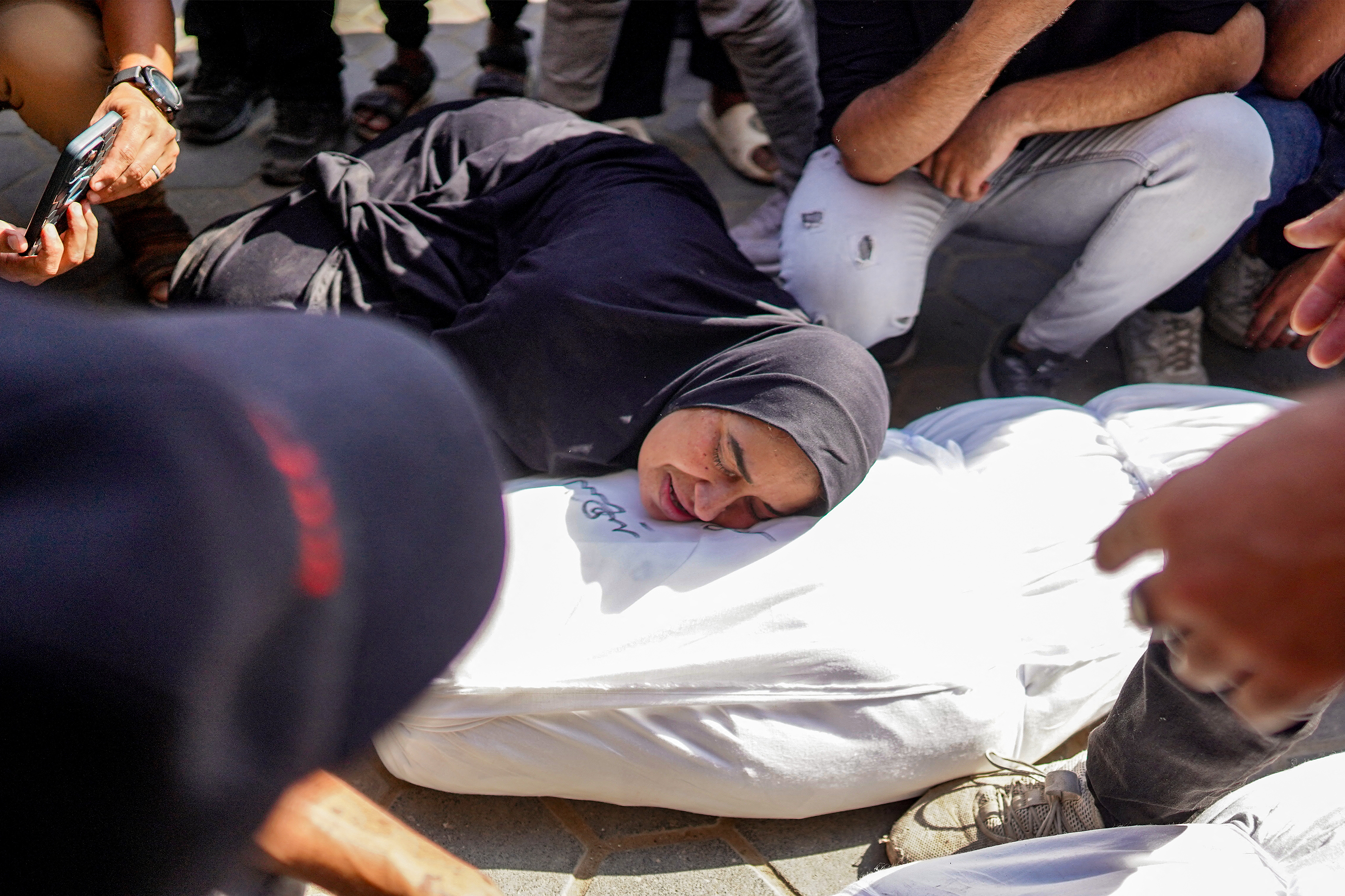 A mother reacts as she mourns by the body of her son who was killed in the aftermath of overnight Israeli bombardment in al-Maghazi