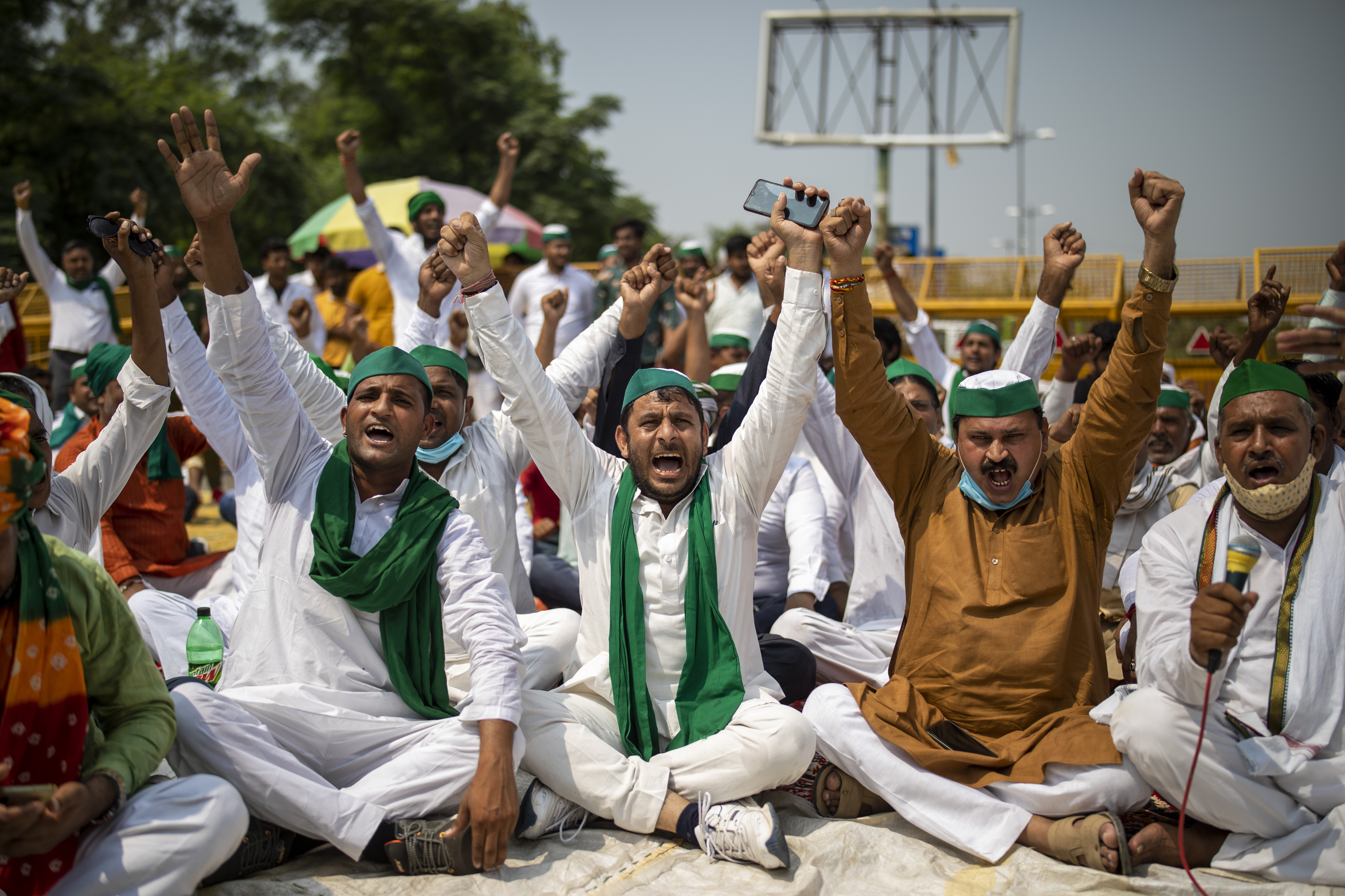 Indian farmers shout slogans as they block a highway during a protest in Noida, India, Friday, Sept. 25, 2020. Hundreds of Indian farmers took to the streets on Friday protesting new laws that the government says will boost growth in the farming sector through private investments, but they fear these are likely to be exploited by private players for buying their crops cheaply. (AP Photo/Altaf Qadri)