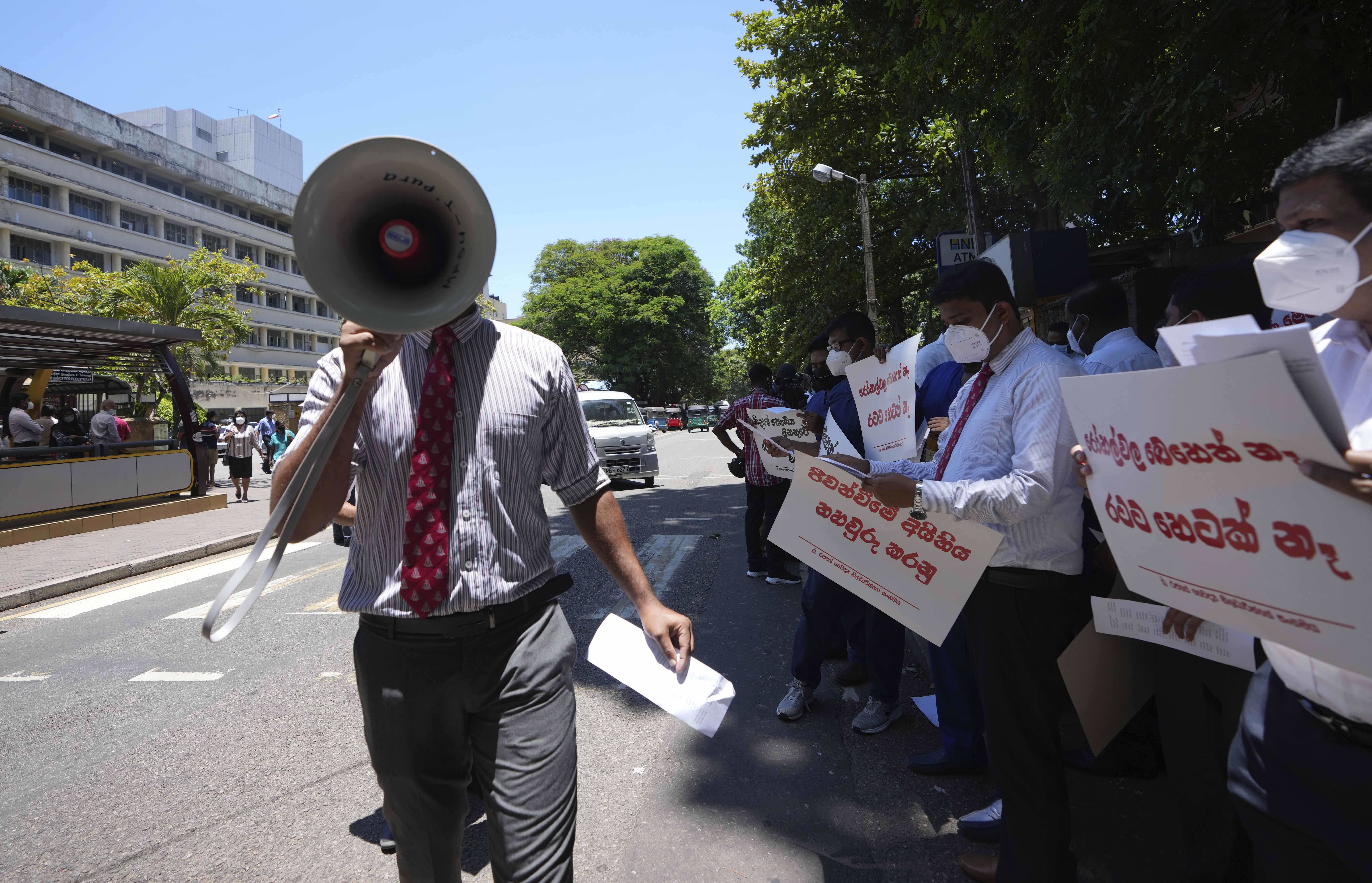 Sri Lankan government doctors protest against the government near the national hospital in Colombo, Sri Lanka, Wednesday, April 6, 2022. For several months, Sri Lankans have endured long lines to buy fuel, cooking gas, foods and medicine, most of which come from abroad. Placards read " No medicines," "Health service is in danger." (AP Photo/Eranga Jayawardena)