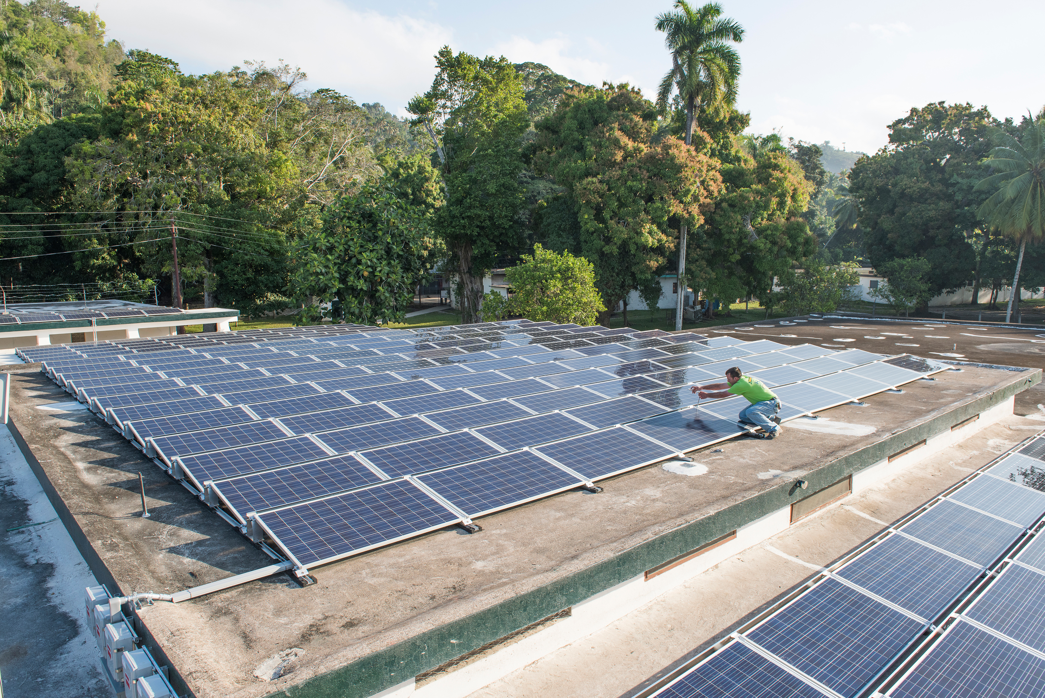 A volunteer with Smucker’s Energy of Pennsylvania puts final touches on an installation of SolarWorld solar panels atop Hospital Lumière in Bonne Fin, Haiti. SolarWorld donated 50 kilowatts of solar panels to dramatically reduce the hospital’s reliance on expensive and faulty diesel generators. Credit: Eric Forberger for SolarWorld.