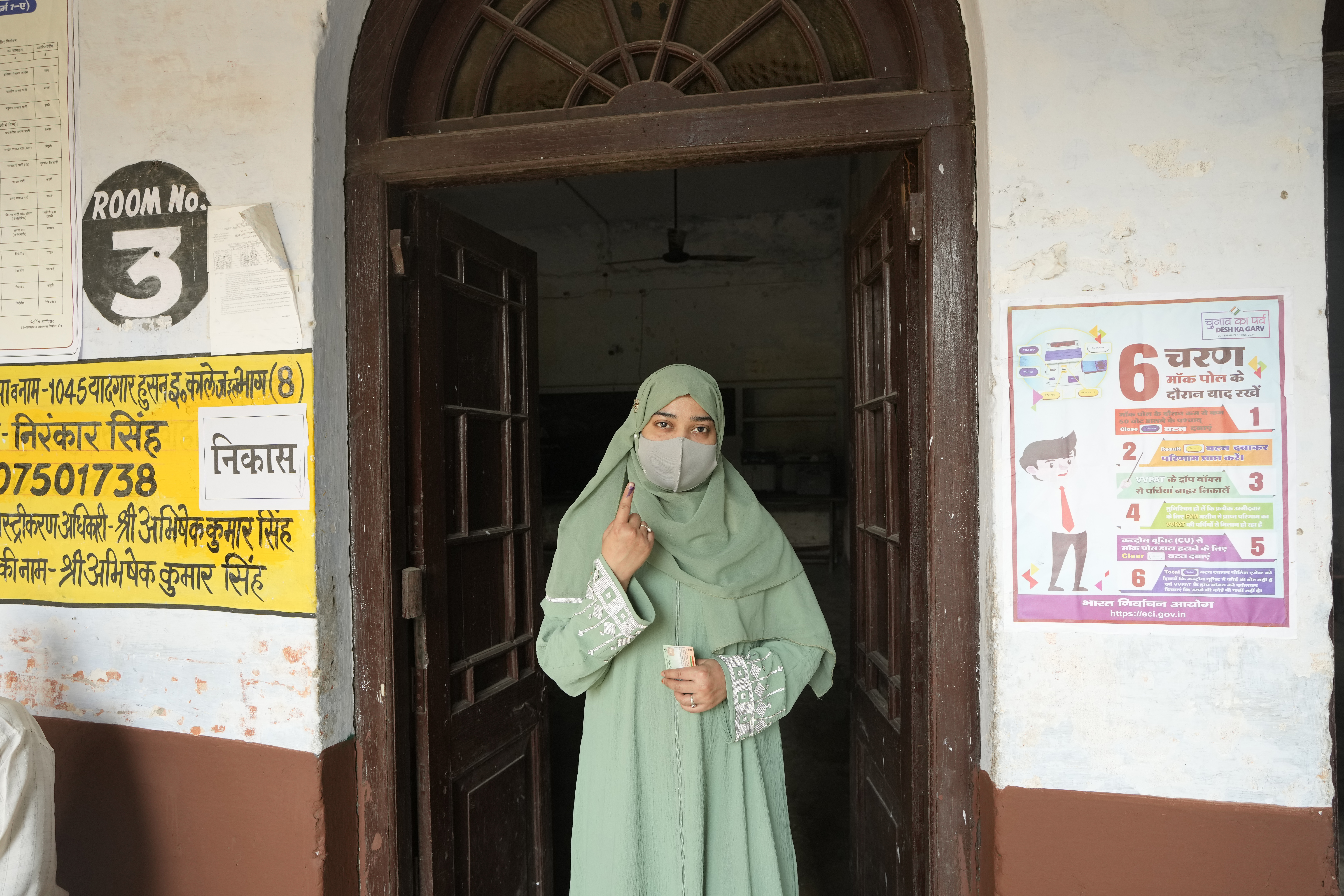A Muslim voter shows her index finger marked with an indelible ink after casting her vote