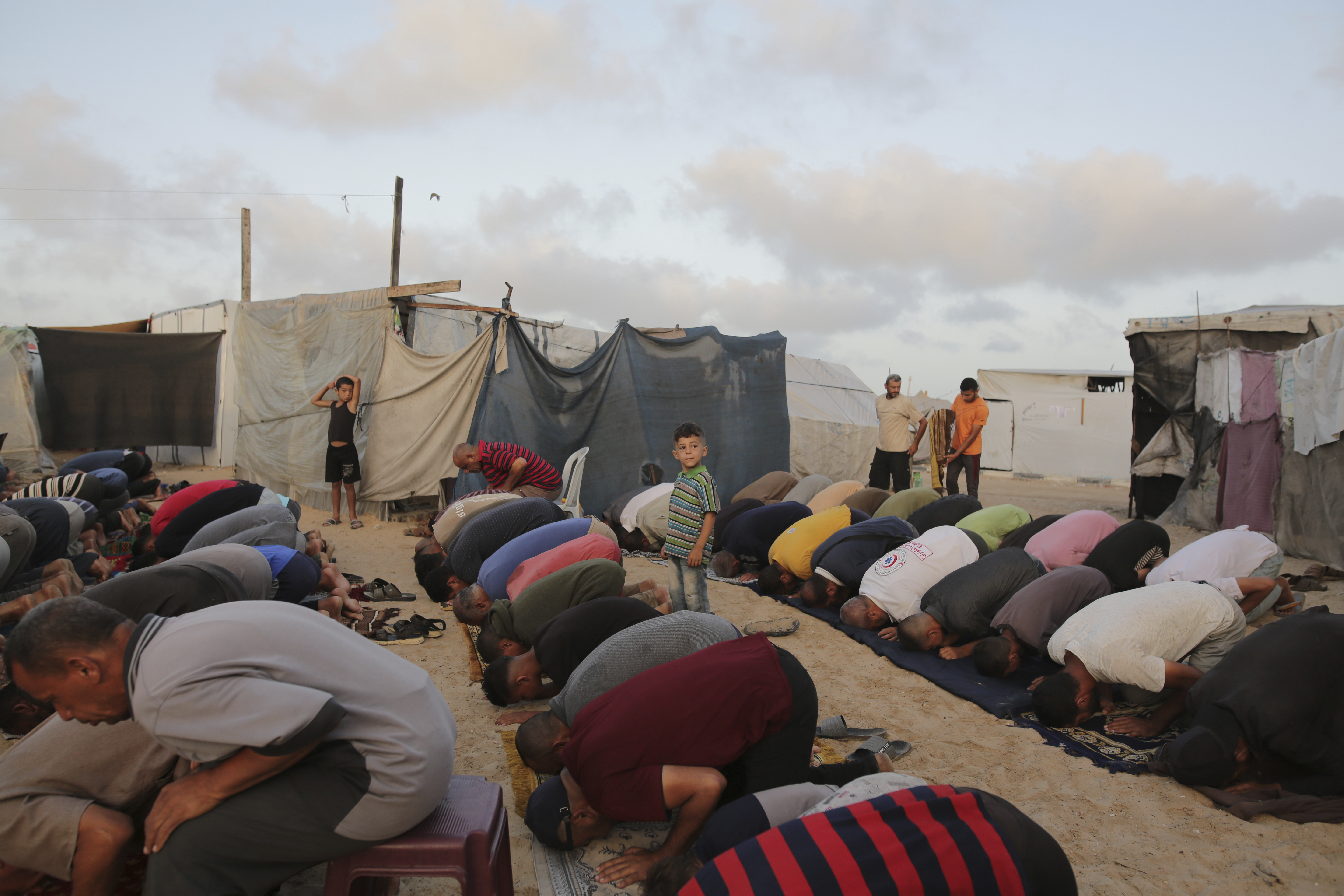 Palestinians displaced by the Israeli air and ground offensive on the Gaza Strip offer Eid al-Adha prayers at a makeshift tent camp Khan Younis, Gaza, Sunday, June 16