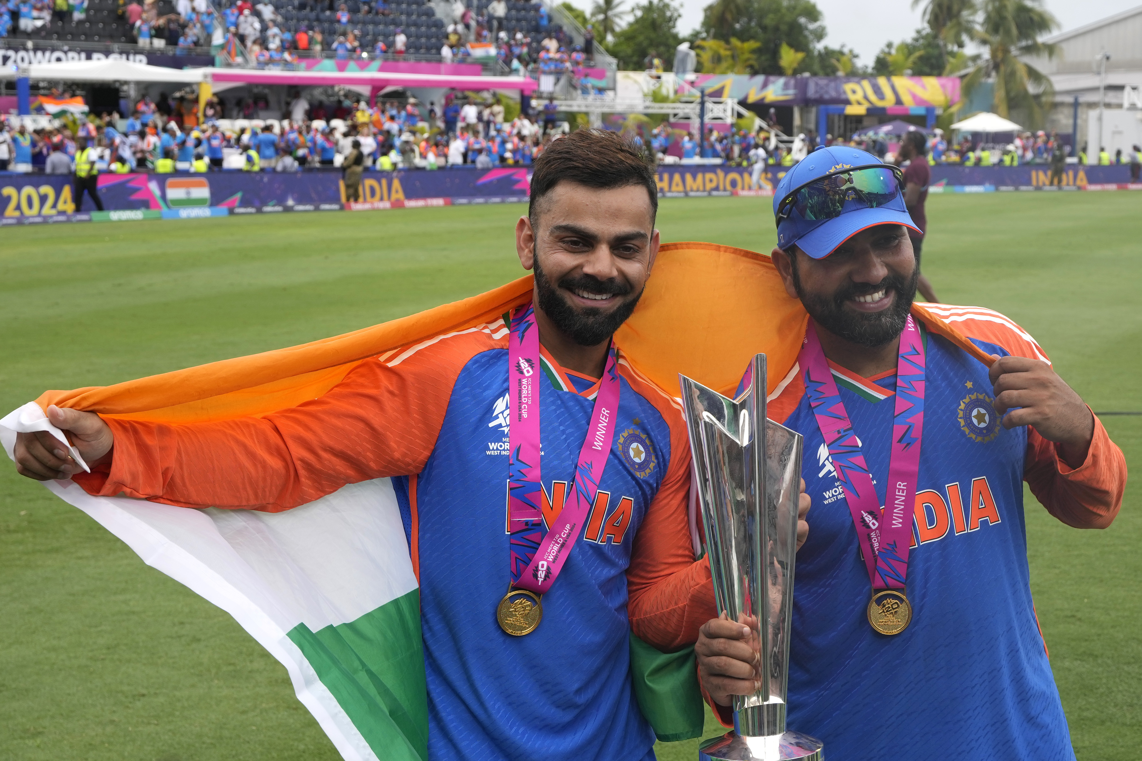 India's Virat Kohli, left, and captain Rohit Sharma pose with the winners trophy after defeating South Africa in the ICC Men's T20 World Cup final cricket match at Kensington Oval in Bridgetown, Barbados, Saturday, June 29, 2024. (AP Photo/Ricardo Mazalan)