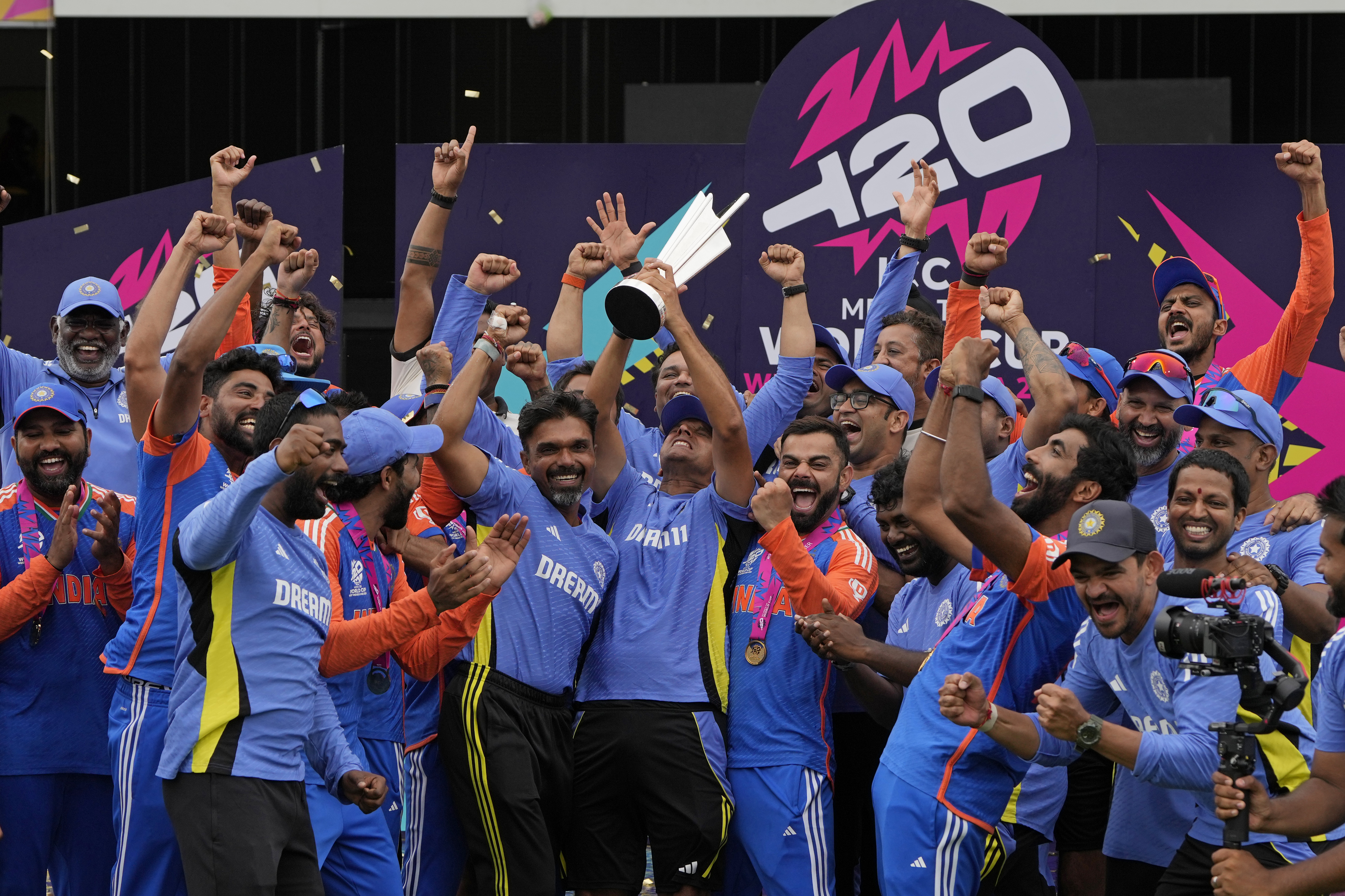 India's head coach Rahul Dravid, center, and Virat Kohli, center right, celebrate with players and team support staff with the winners trophy after defeating South Africa in the ICC Men's T20 World Cup final cricket match at Kensington Oval in Bridgetown, Barbados, Saturday, June 29, 2024. (AP Photo/Ricardo Mazalan)